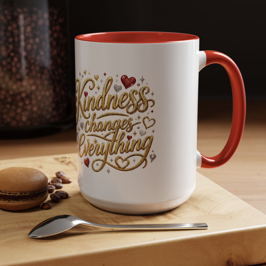 Inspirational ceramic coffee mug featuring the hand-lettered message “Kindness Changes Everything” with gold flourishes, hearts, and colorful accent handle and interior.