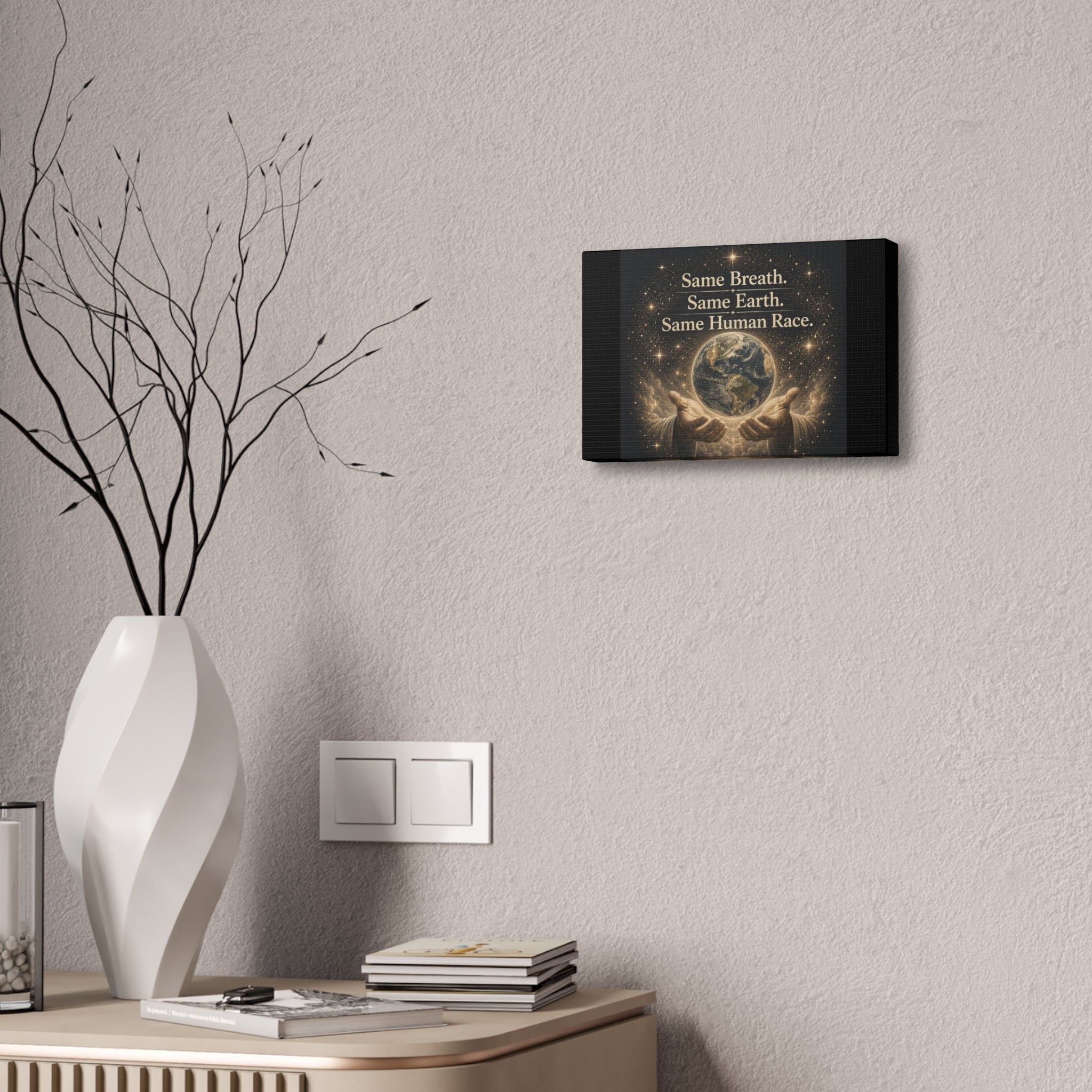 Inspirational canvas wall art featuring the earth held in gentle hands surrounded by glowing stars with the quote “Same Breath. Same Earth. Same Human Race.” in warm golden tones.