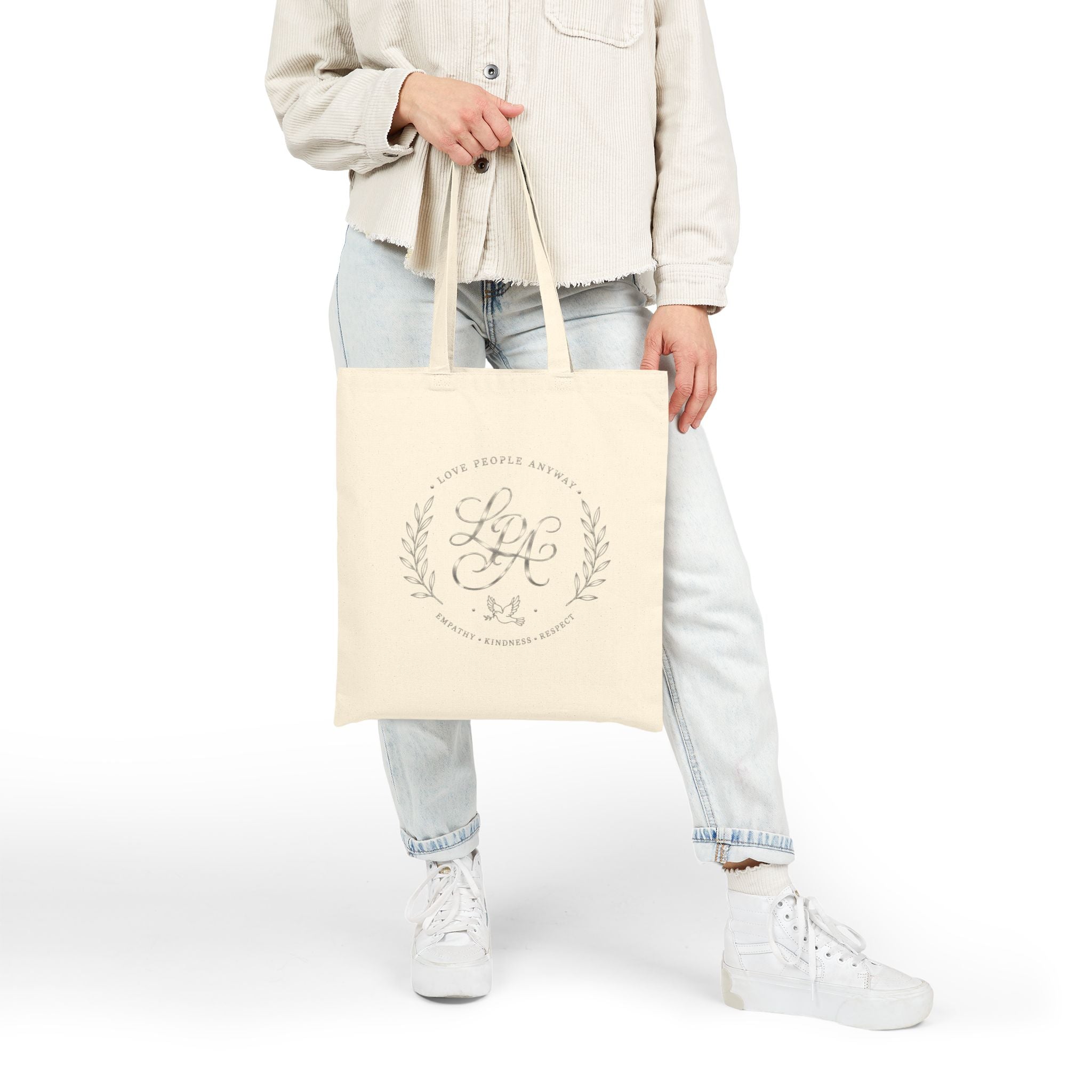 Elegant cotton canvas tote bag featuring a silver monogram crest, laurel branches, dove with olive branch, and the message “Love People Anyway” with empathy, kindness, and respect accents.