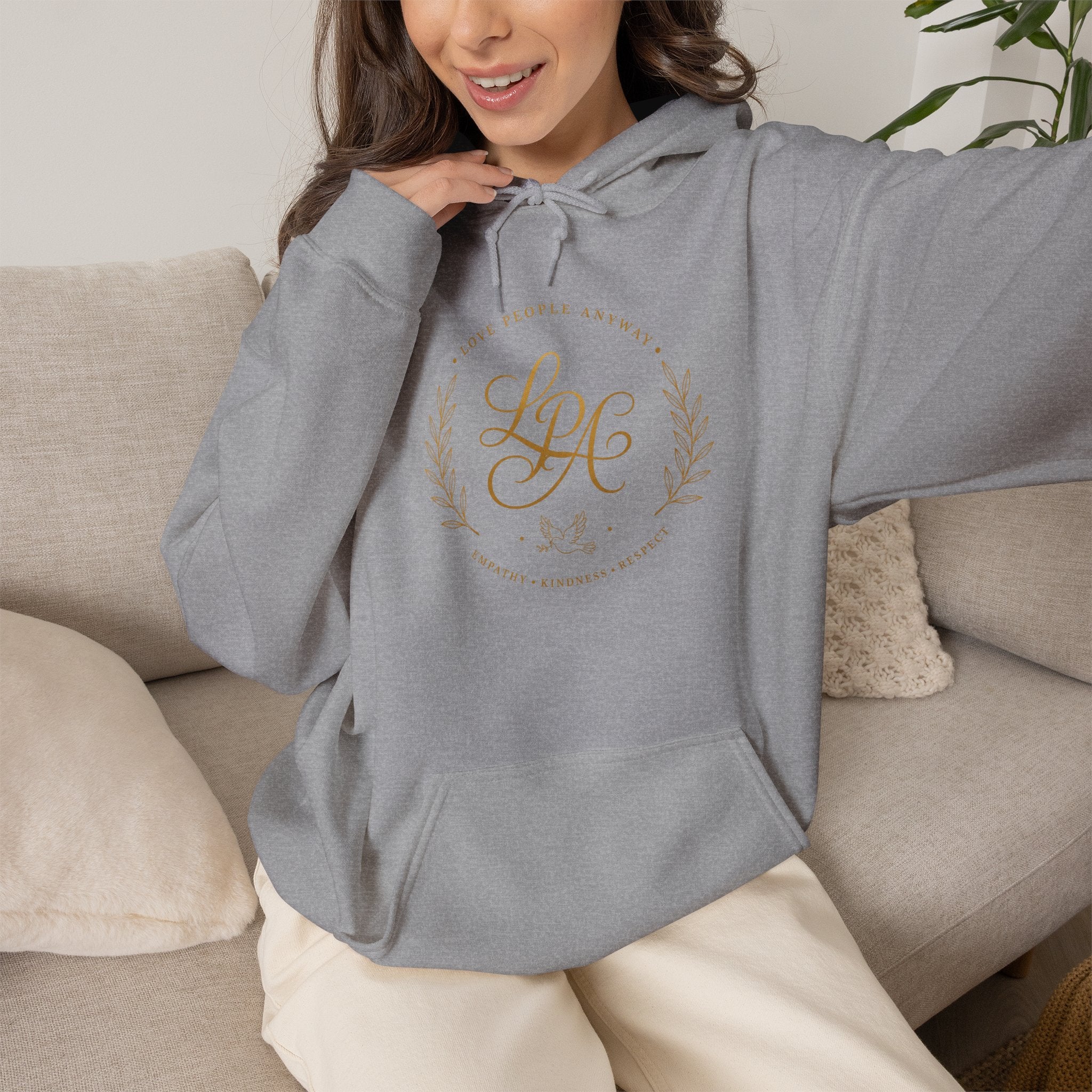 Inspirational Christian hoodie featuring elegant “Love People Anyway” script typography on a soft, cozy hooded sweatshirt designed to encourage kindness and compassion.