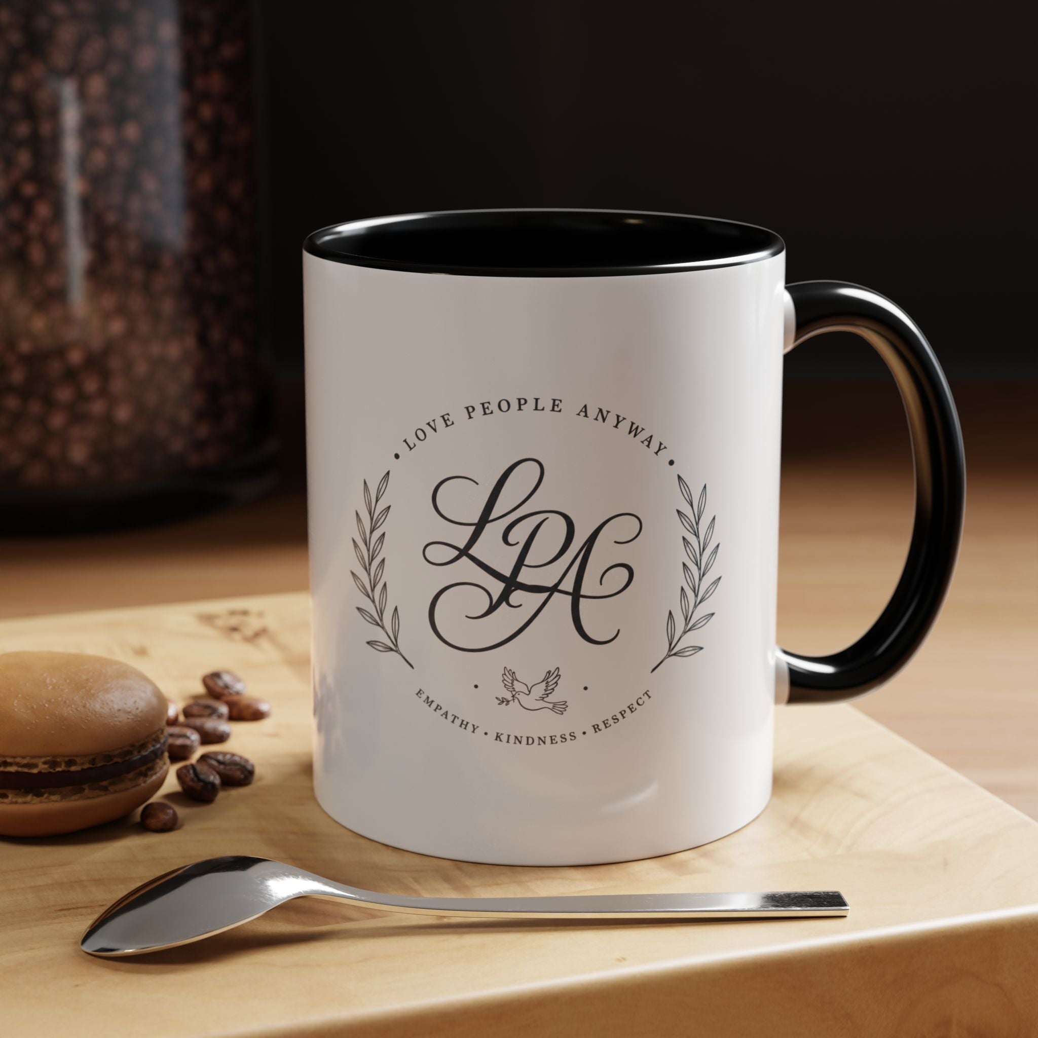 Personalized ceramic accent coffee mug featuring a custom monogram crest and the inspirational message “Love People Anyway” with colorful handle and interior accents.