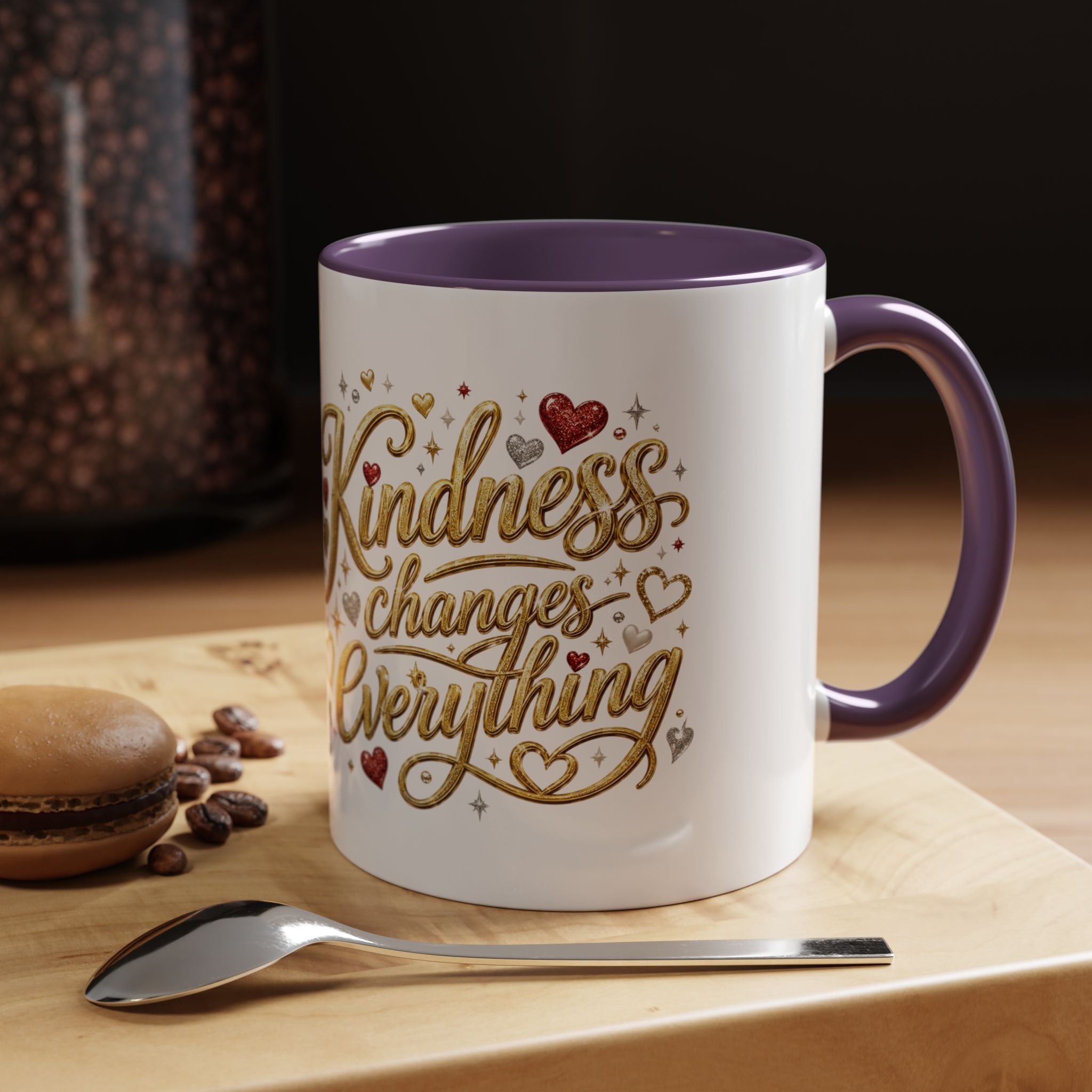 Inspirational ceramic coffee mug featuring the hand-lettered message “Kindness Changes Everything” with gold flourishes, hearts, and colorful accent handle and interior.