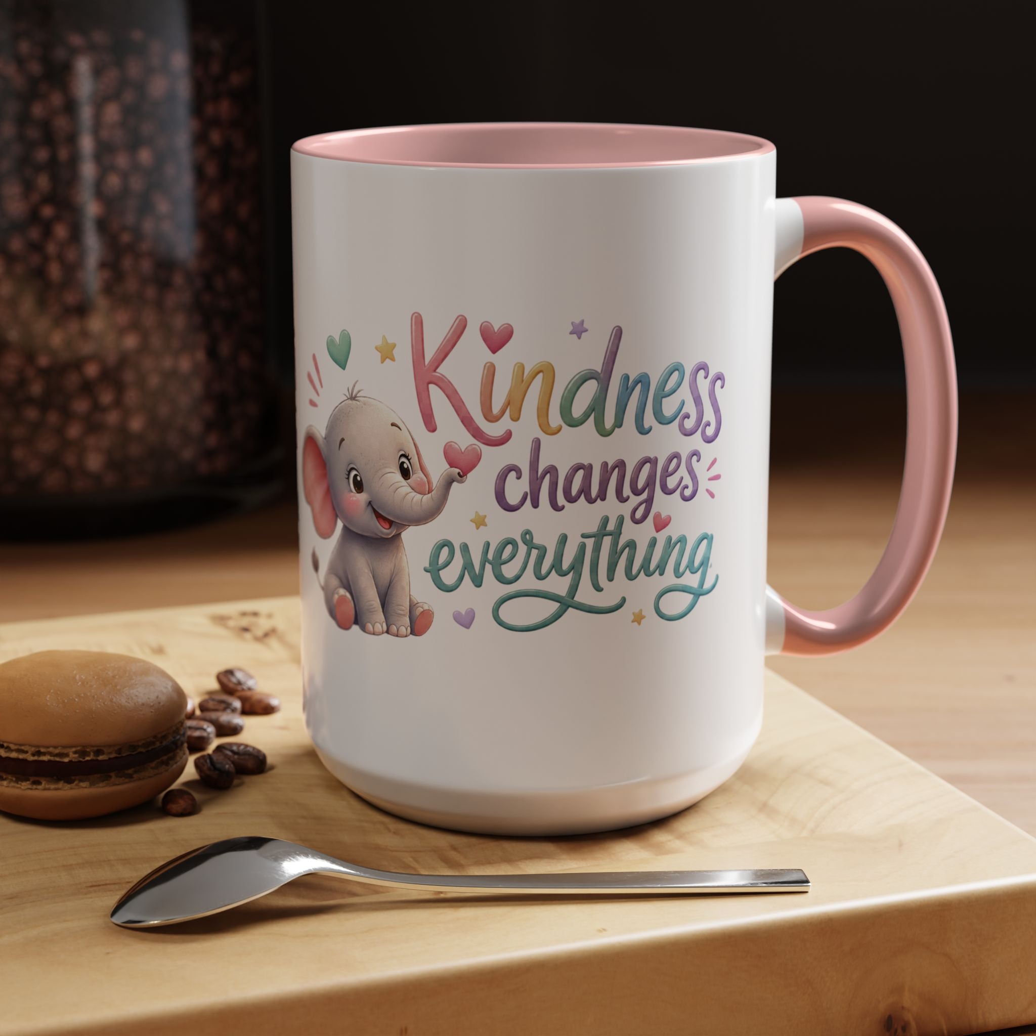 Cute ceramic coffee mug featuring a pastel baby elephant and the uplifting message “Kindness Changes Everything” with colorful accent handle and interior.