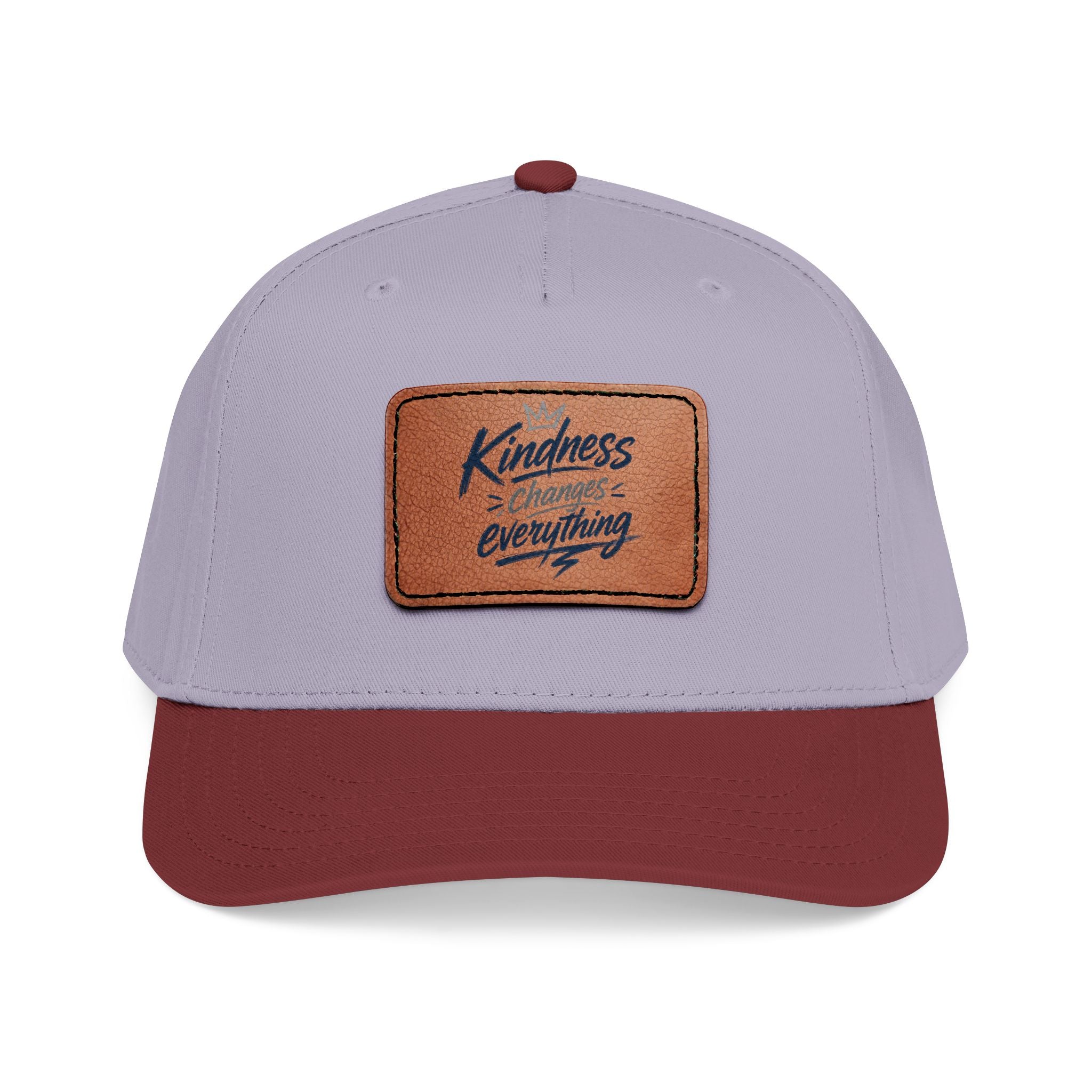Vintage-inspired baseball cap featuring a brown leather patch with the phrase “Kindness Changes Everything” on a structured mid-profile snapback hat.