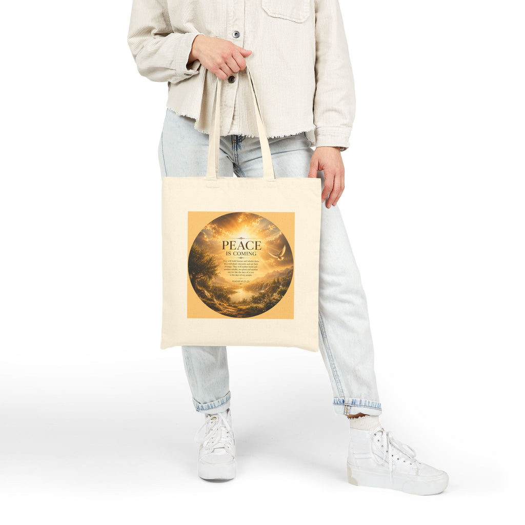 Christian cotton canvas tote bag featuring Isaiah 65:21-25 and the message “Peace Is Coming,” with golden paradise landscape artwork, waterfalls, mountains, river, white dove, and radiant sunlight.
