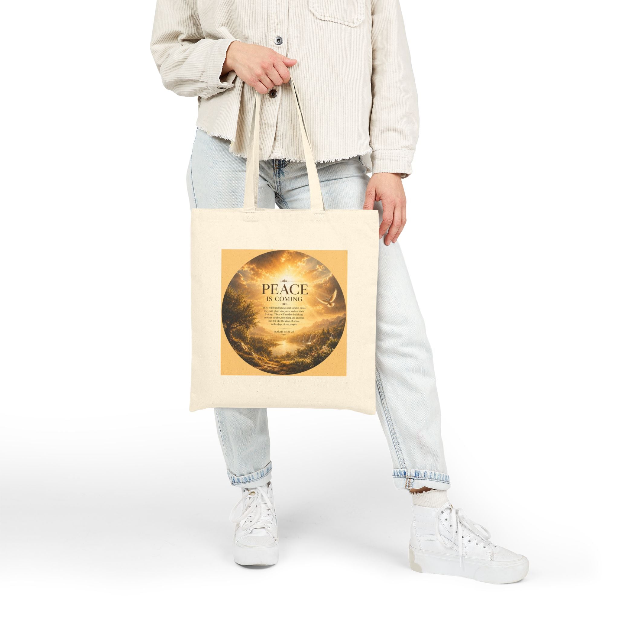Christian cotton canvas tote bag featuring Isaiah 65:21-25 and the message “Peace Is Coming,” with golden paradise landscape artwork, waterfalls, mountains, river, white dove, and radiant sunlight.
