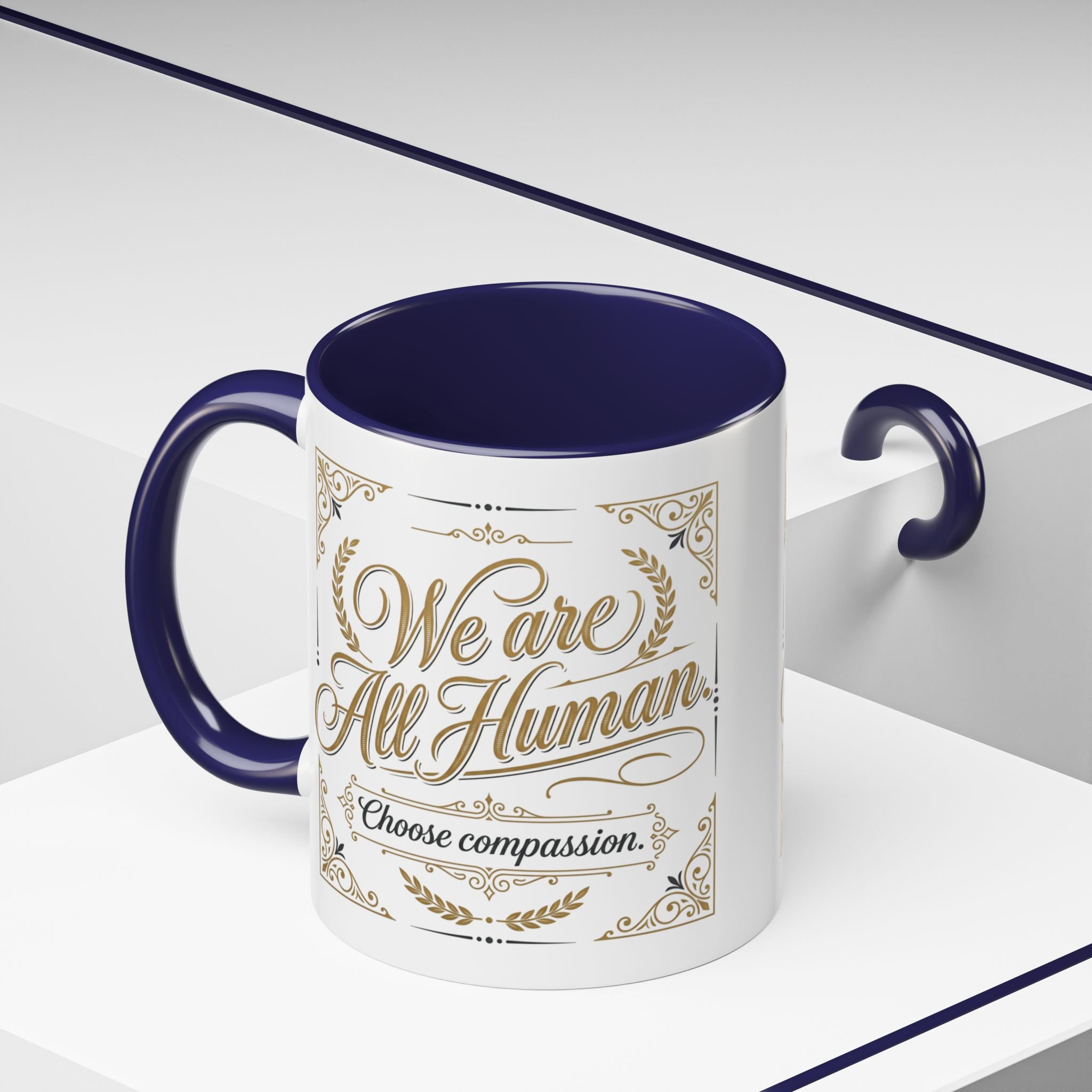 Inspirational ceramic accent coffee mug featuring “We Are All Human – Choose Compassion” in vintage-style gold lettering with decorative flourishes and black accent handle and interior.