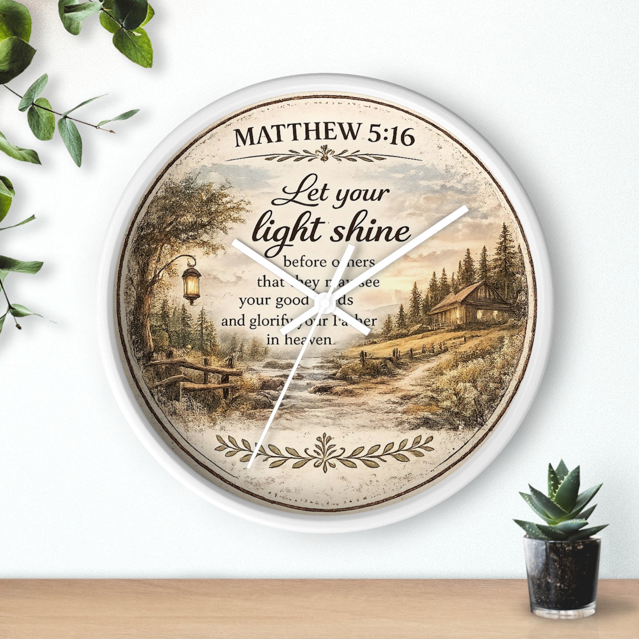 Inspirational Christian wall clock featuring Matthew 5:16 with a lantern-lit path, pine trees, rustic cottage, and warm countryside artwork in vintage farmhouse style.