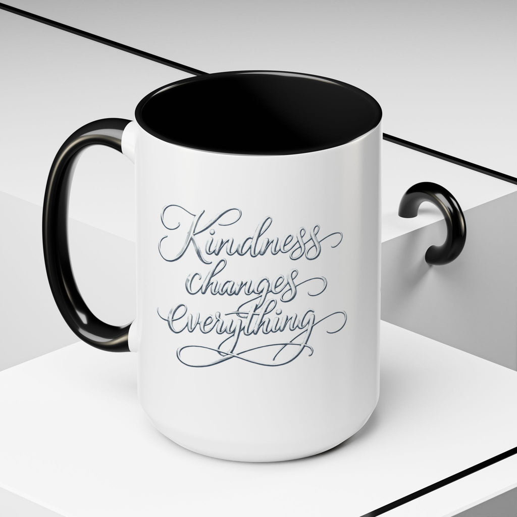 Inspirational ceramic accent coffee mug featuring elegant silver hand-lettered “Kindness Changes Everything” typography with colorful handle and interior accents.