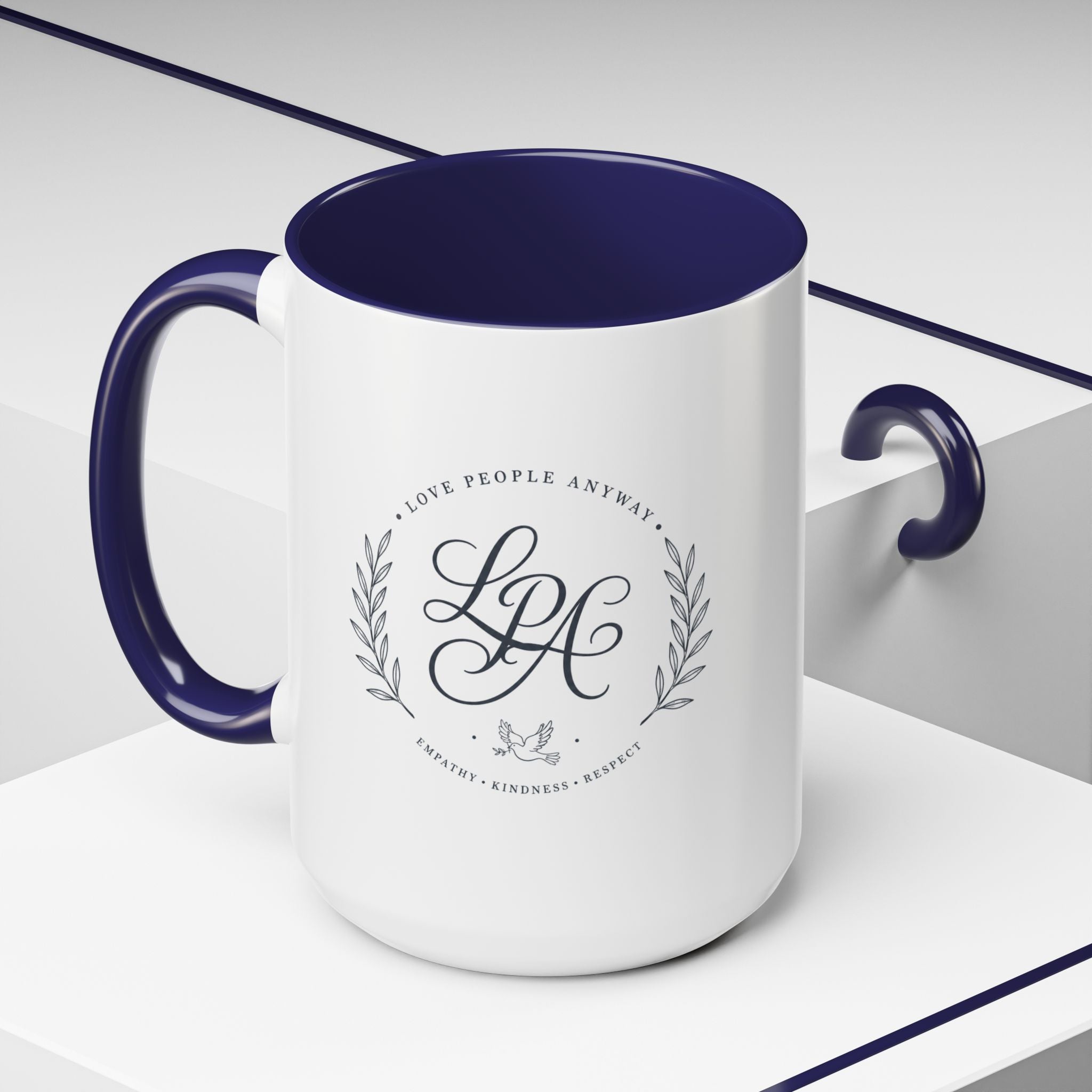 Personalized ceramic accent coffee mug featuring a custom monogram crest and the inspirational message “Love People Anyway” with colorful handle and interior accents.