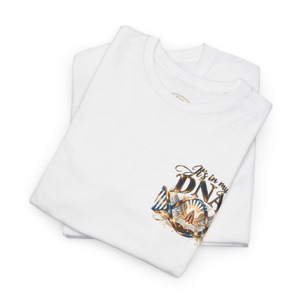 A folded white t-shirt with a graphic print on the front that reads 'It's in my DNA' in brown and gold lettering, accompanied by a stylized illustration of a 47-year-old man's face and a heart. The t-shirt is photographed on a seamless white background.