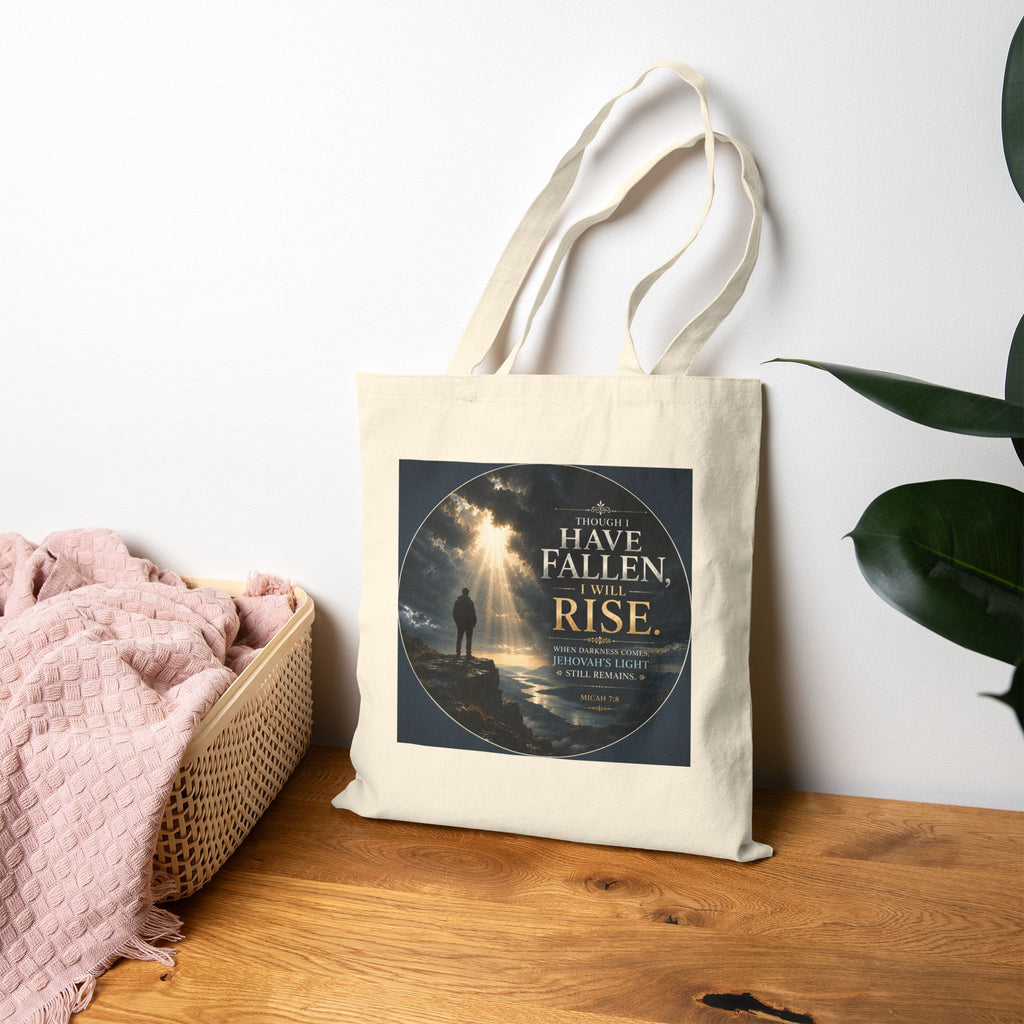 Christian cotton canvas tote bag featuring Micah 7:8 and the message “Though I Have Fallen, I Will Rise,” with dramatic mountain landscape artwork, storm clouds, rays of light, and inspirational faith-based design.
