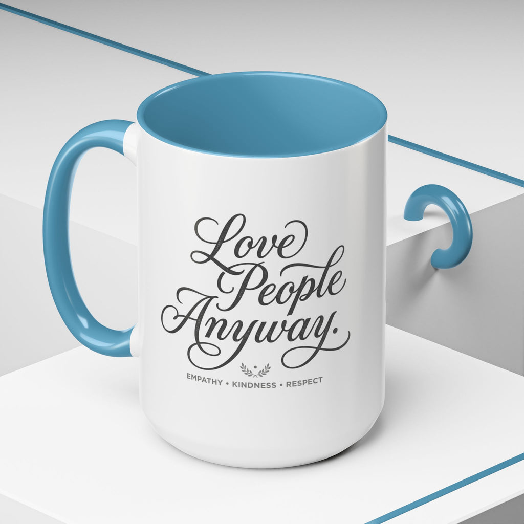 Inspirational ceramic accent coffee mug featuring hand-lettered “Love People Anyway” typography with empathy, kindness, and respect message on a glossy white mug with colorful handle and interior.
