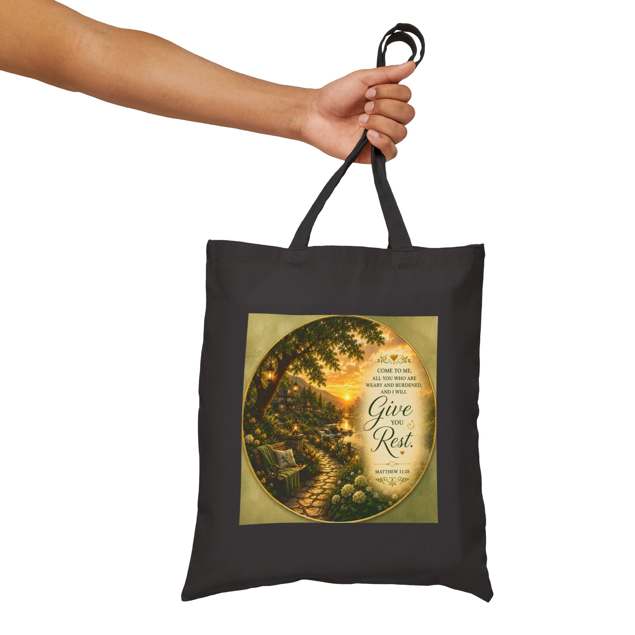 Christian cotton canvas tote bag featuring Matthew 11:28, “Come to Me, all you who are weary and burdened, and I will give you rest,” with peaceful garden pathway, glowing lanterns, riverside cottages, blooming flowers, and sunset artwork.