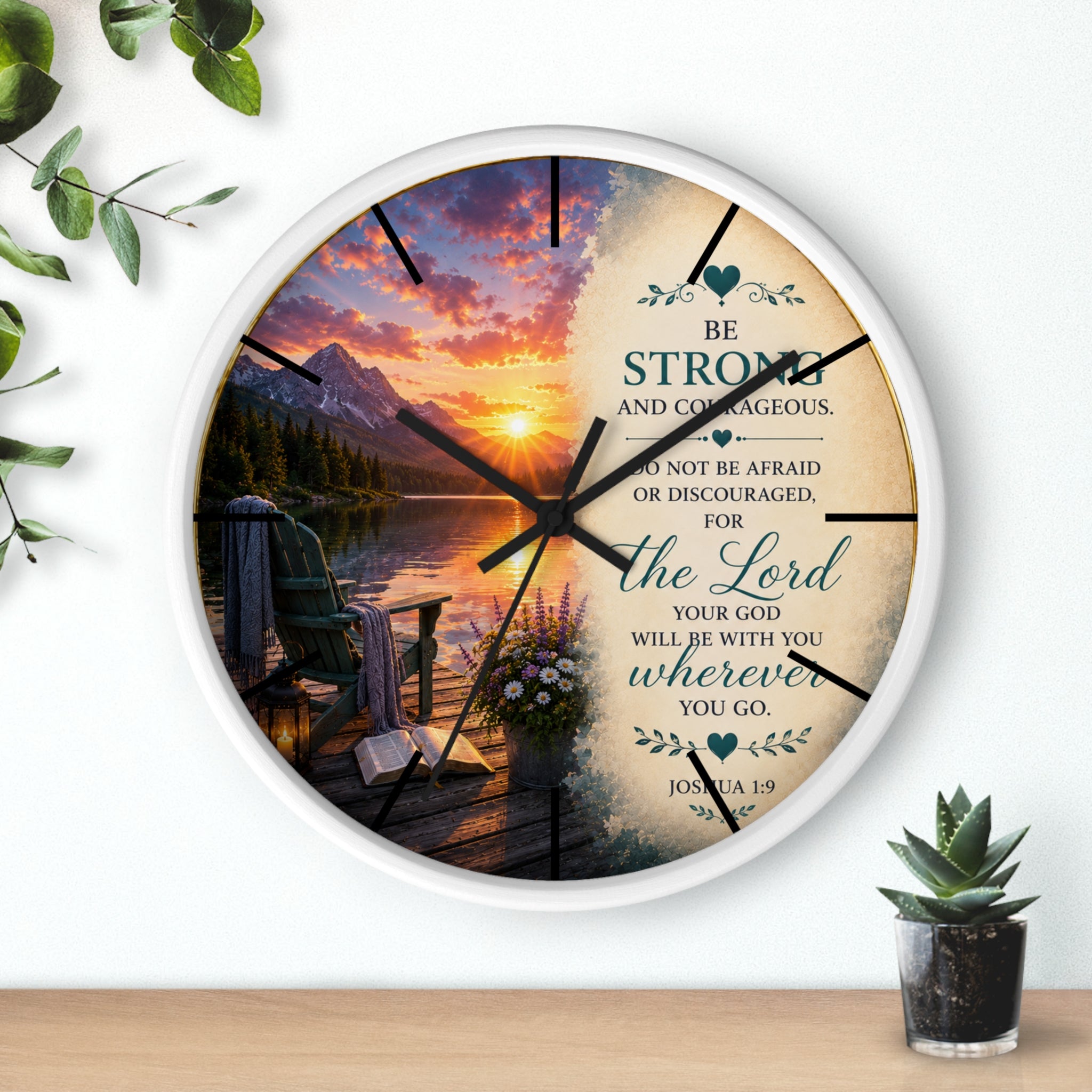 Inspirational Christian wall clock featuring a peaceful lakeside sunrise, mountain scenery, and Joshua 1:9 scripture encouraging strength and courage.