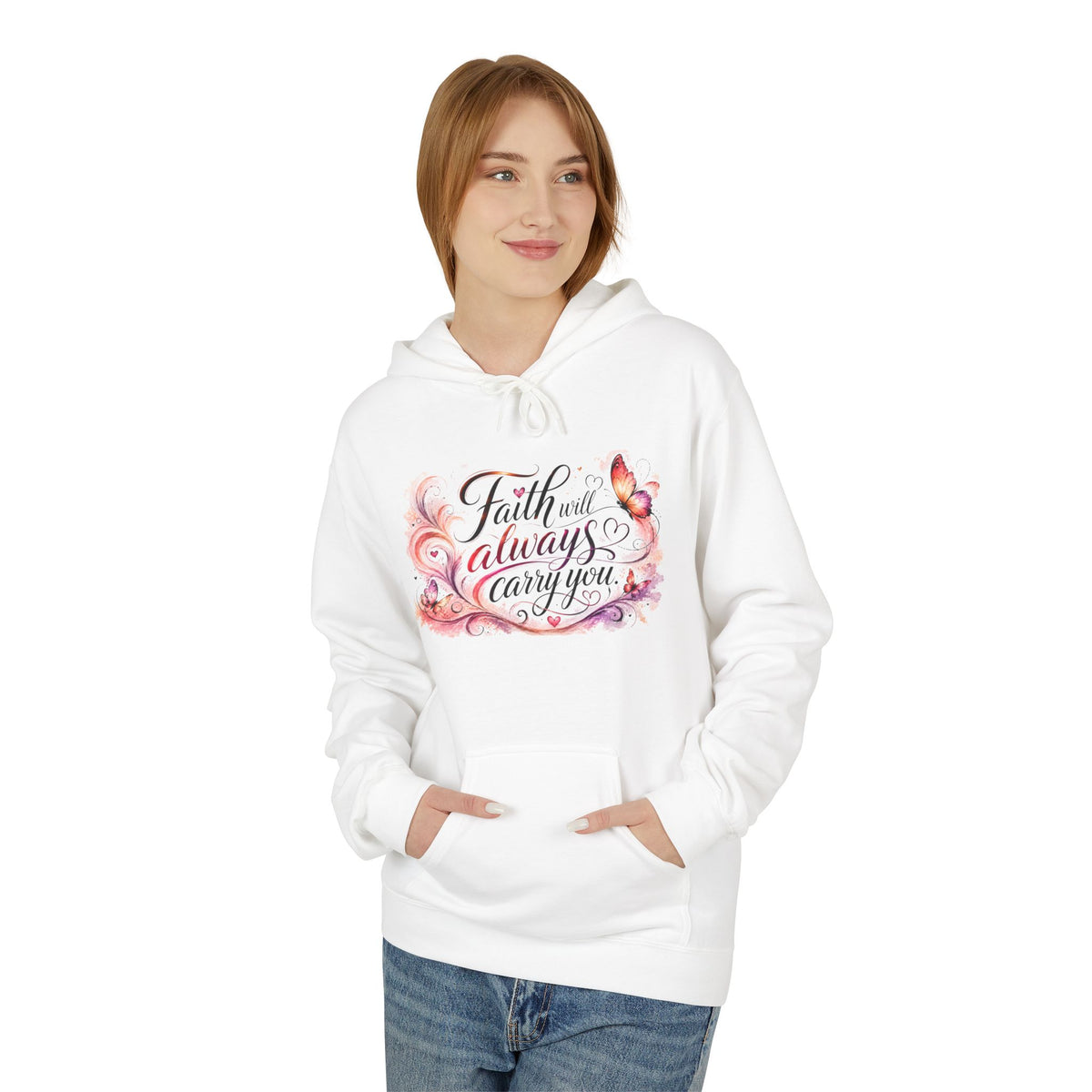 A woman wearing a white pullover hoodie with a colorful graphic on the chest that reads 'Faith will always carry you' in black script with pink, purple, and orange floral accents. She is also wearing blue jeans, set against a plain white background.