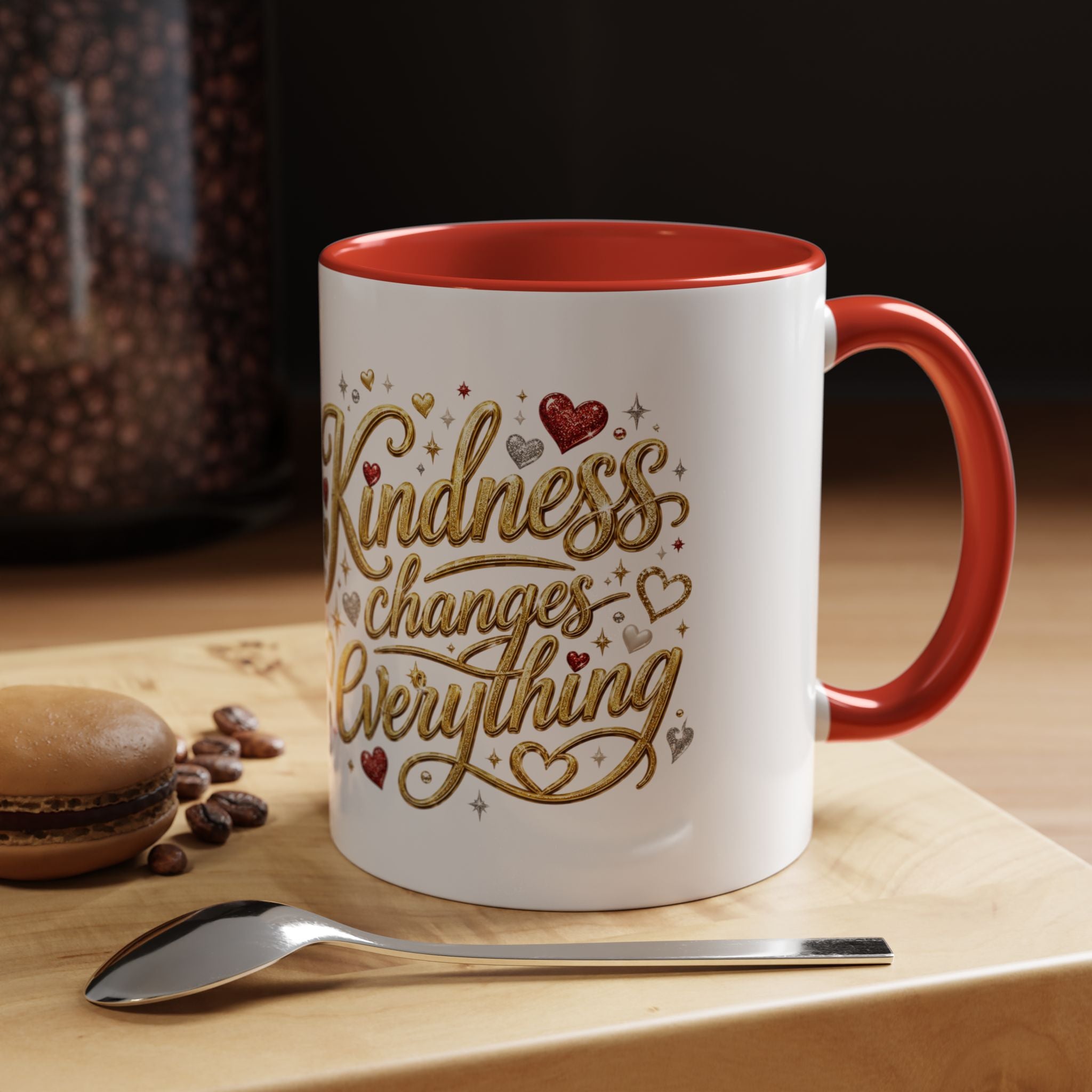 Inspirational ceramic coffee mug featuring the hand-lettered message “Kindness Changes Everything” with gold flourishes, hearts, and colorful accent handle and interior.