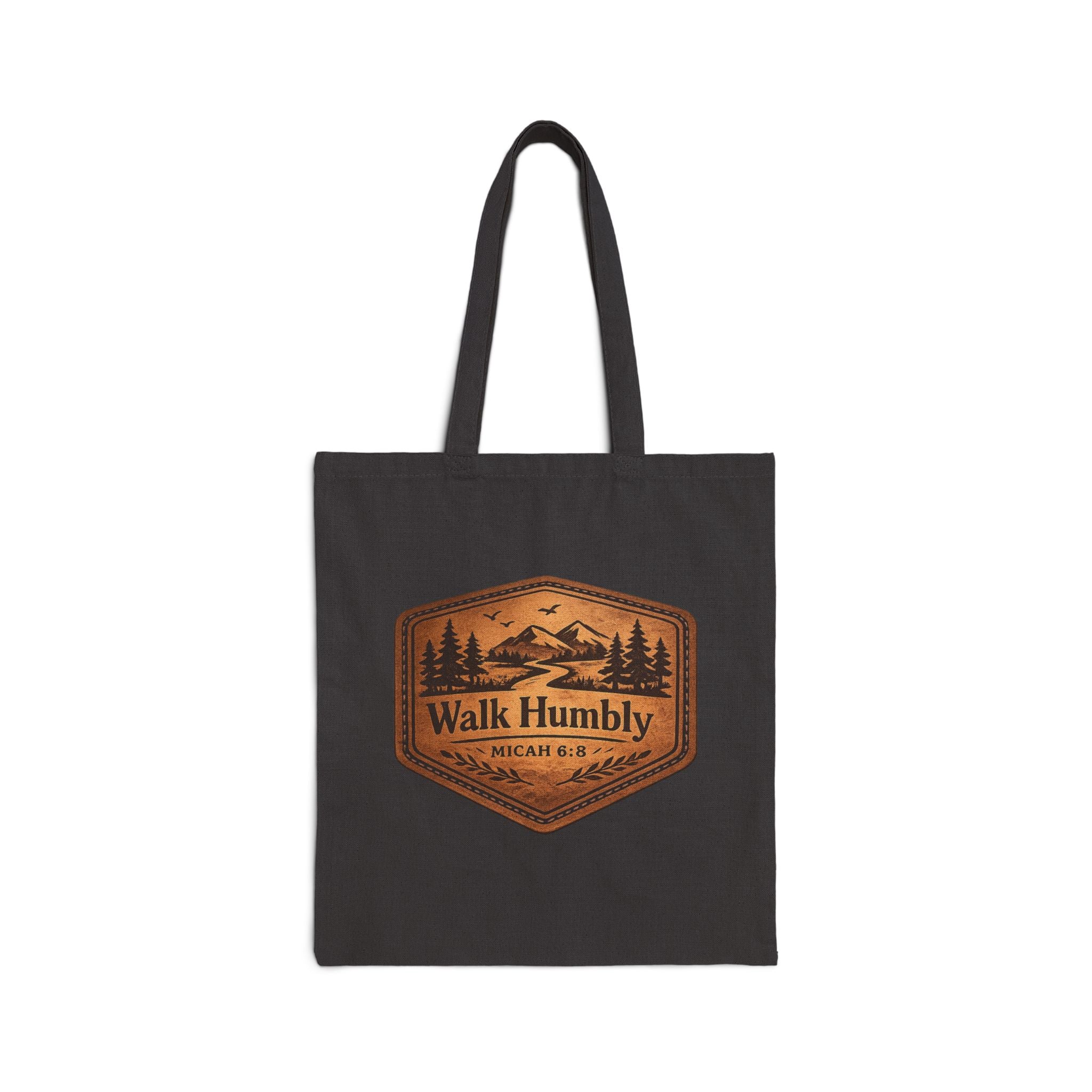 Rustic Christian cotton canvas tote bag featuring Micah 6:8 and the message “Walk Humbly,” with vintage mountain landscape artwork, pine trees, birds, and a winding trail in a leather-patch style design.