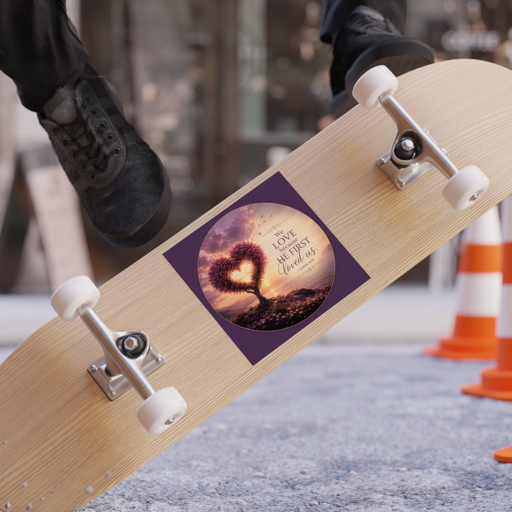 Skateboard with a heart-shaped tree design and 'We love every second' text on a blurred background.