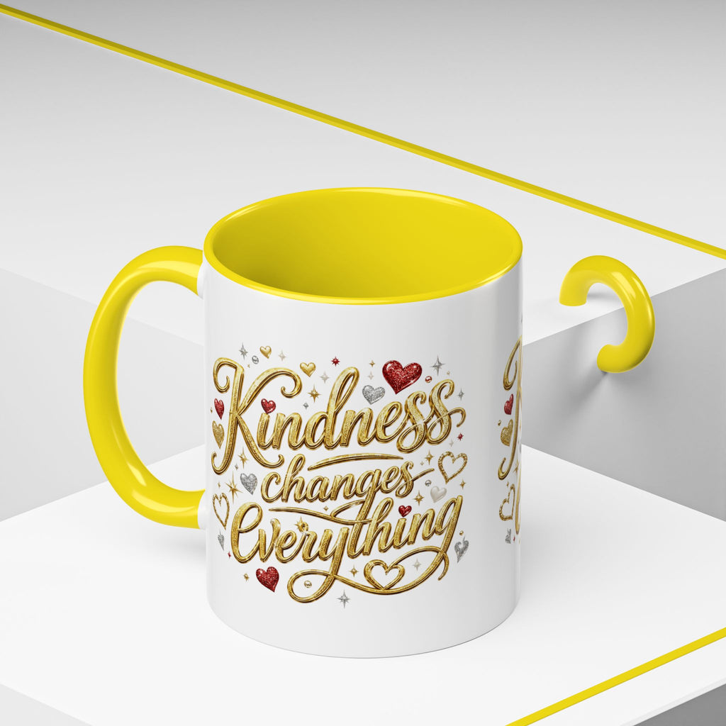 Inspirational ceramic coffee mug featuring the hand-lettered message “Kindness Changes Everything” with gold flourishes, hearts, and colorful accent handle and interior.