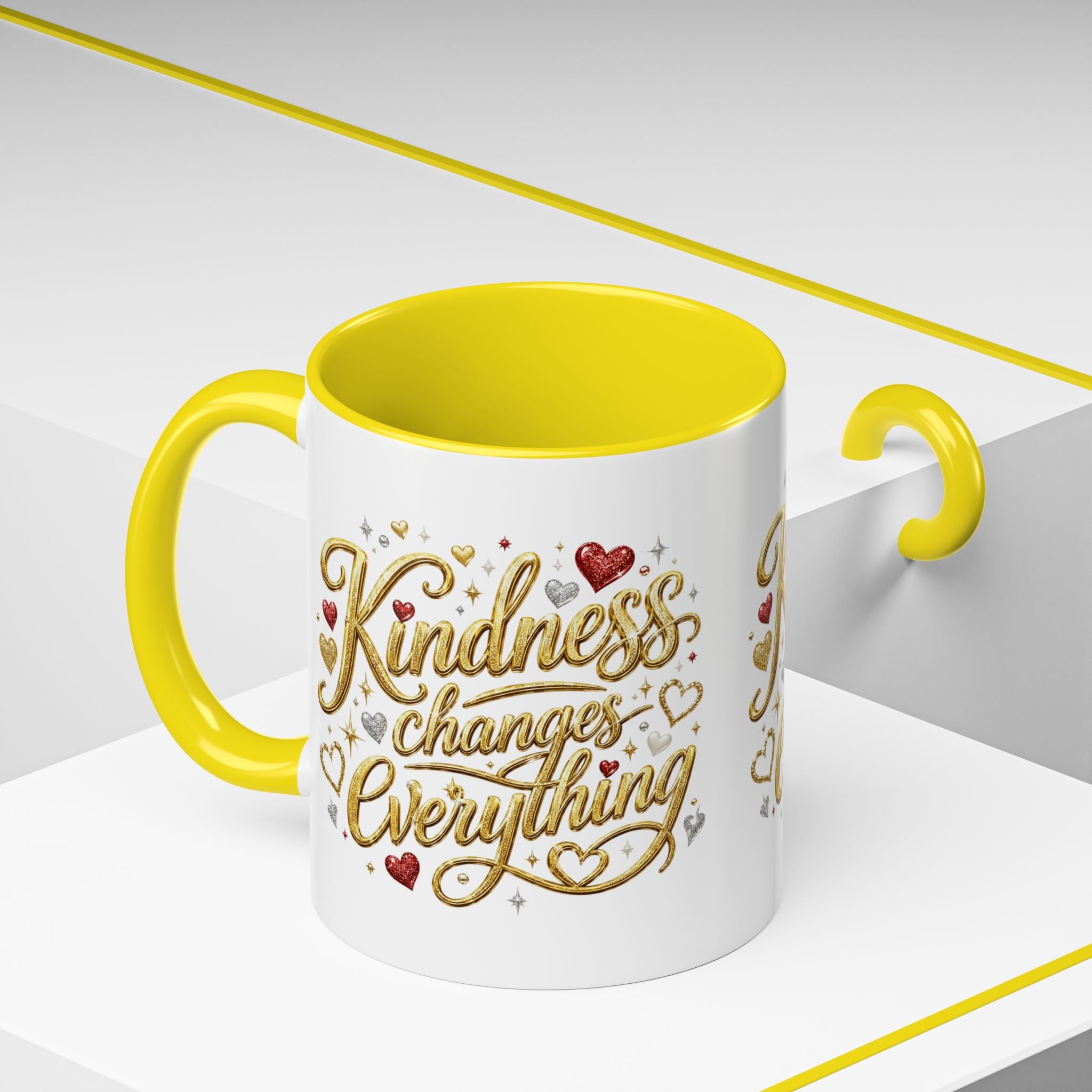 Inspirational ceramic coffee mug featuring the hand-lettered message “Kindness Changes Everything” with gold flourishes, hearts, and colorful accent handle and interior.