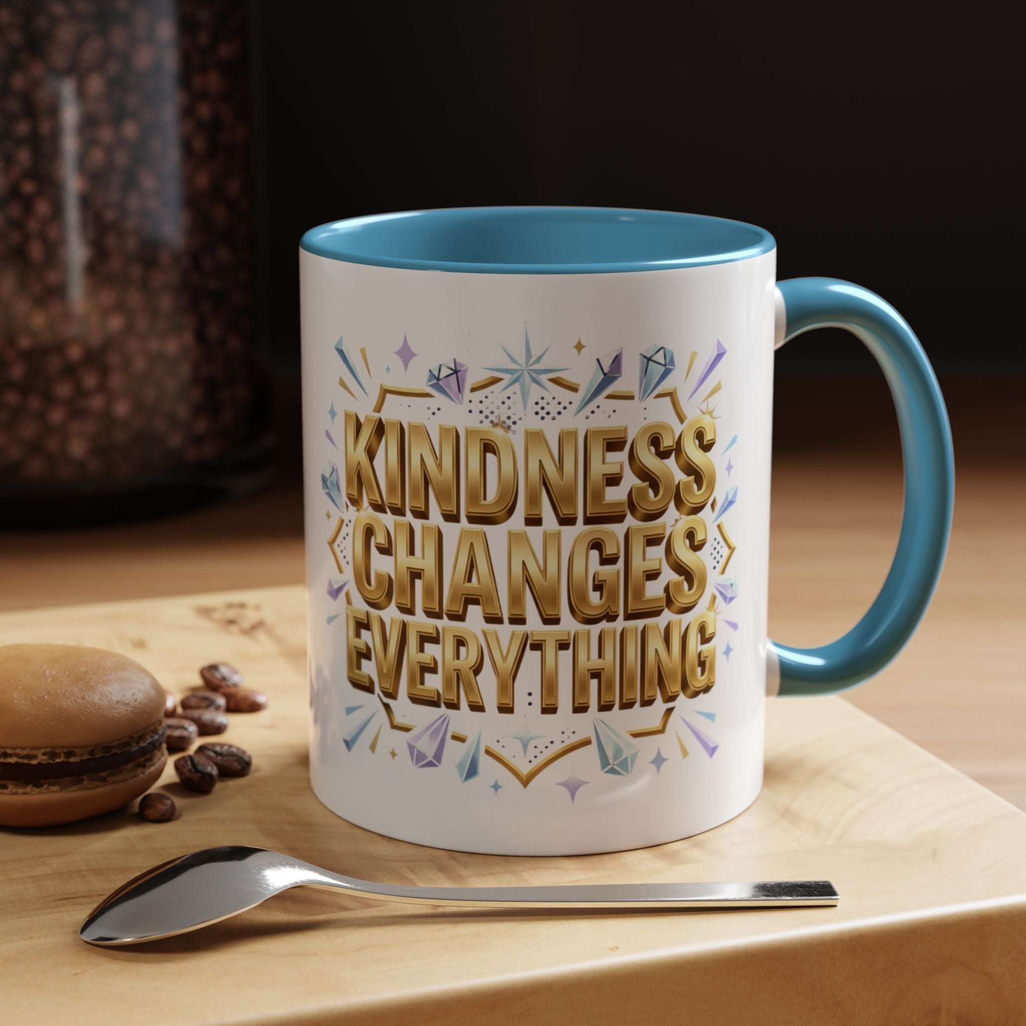 Inspirational ceramic accent coffee mug featuring “Kindness Changes Everything” in elegant gold script with sparkles and colorful accent handle and interior.