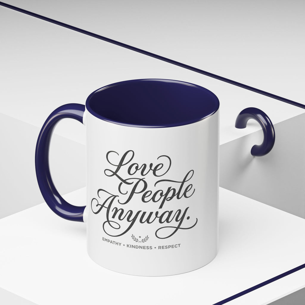 Inspirational ceramic accent coffee mug featuring hand-lettered “Love People Anyway” typography with empathy, kindness, and respect message on a glossy white mug with colorful handle and interior.