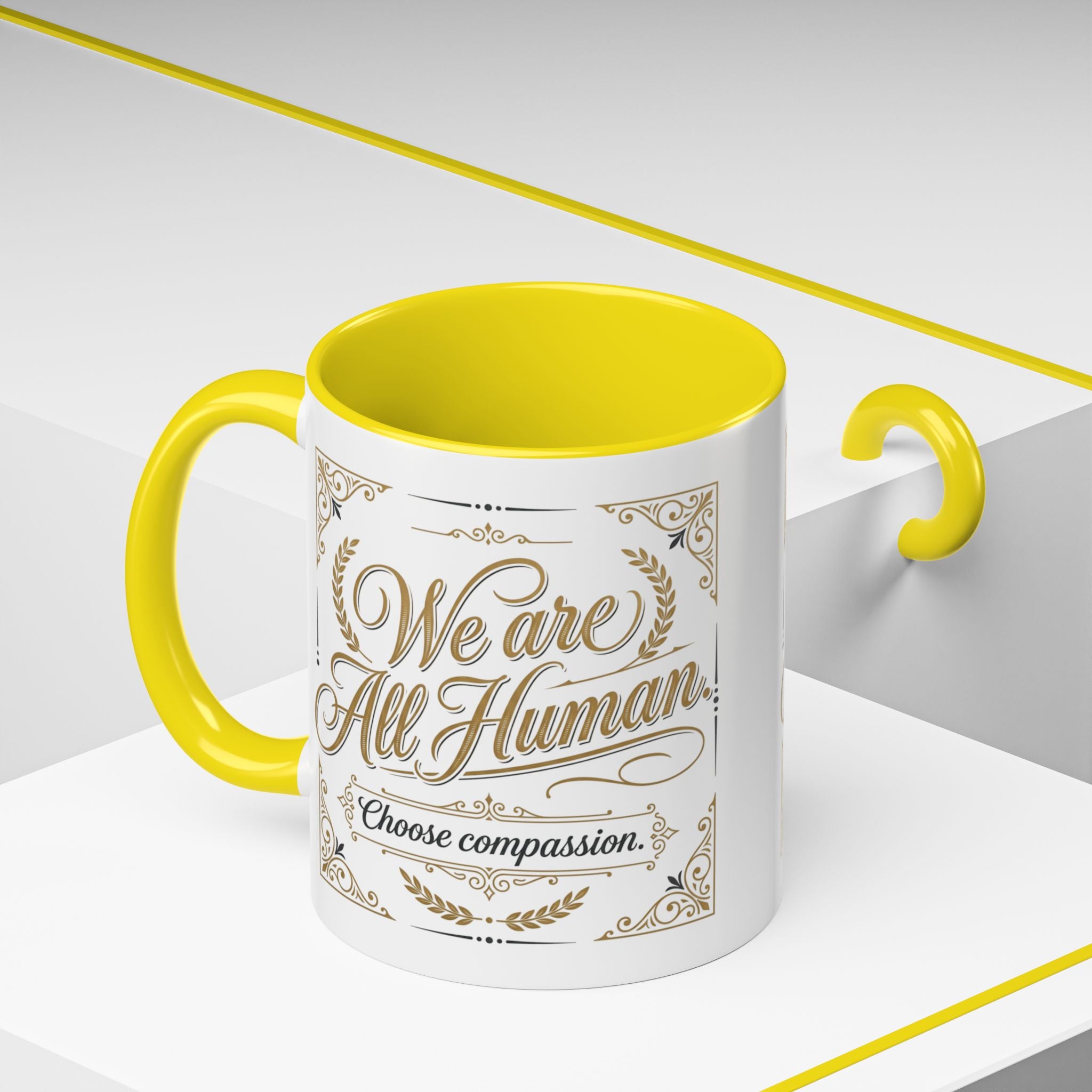 Inspirational ceramic accent coffee mug featuring “We Are All Human – Choose Compassion” in vintage-style gold lettering with decorative flourishes and black accent handle and interior.