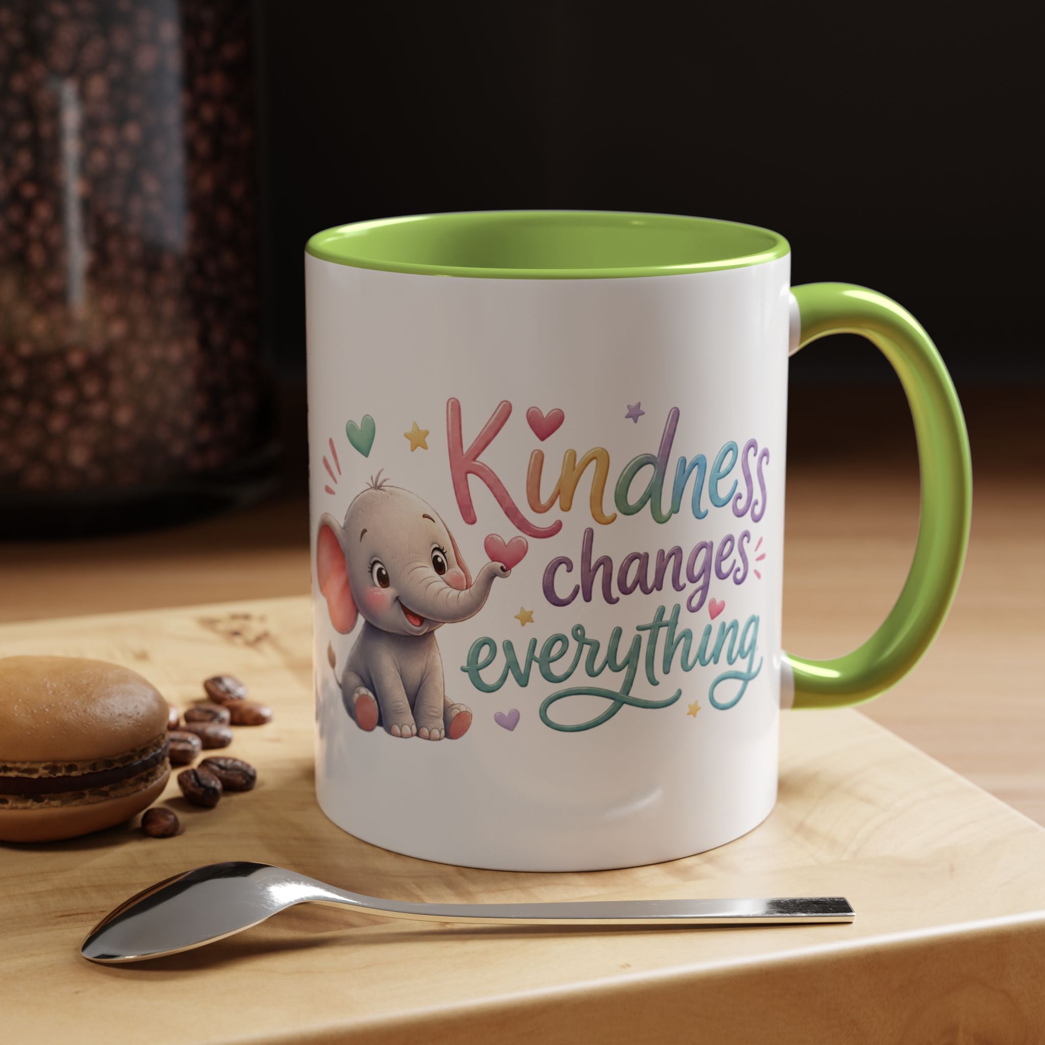 Cute ceramic coffee mug featuring a pastel baby elephant and the uplifting message “Kindness Changes Everything” with colorful accent handle and interior.