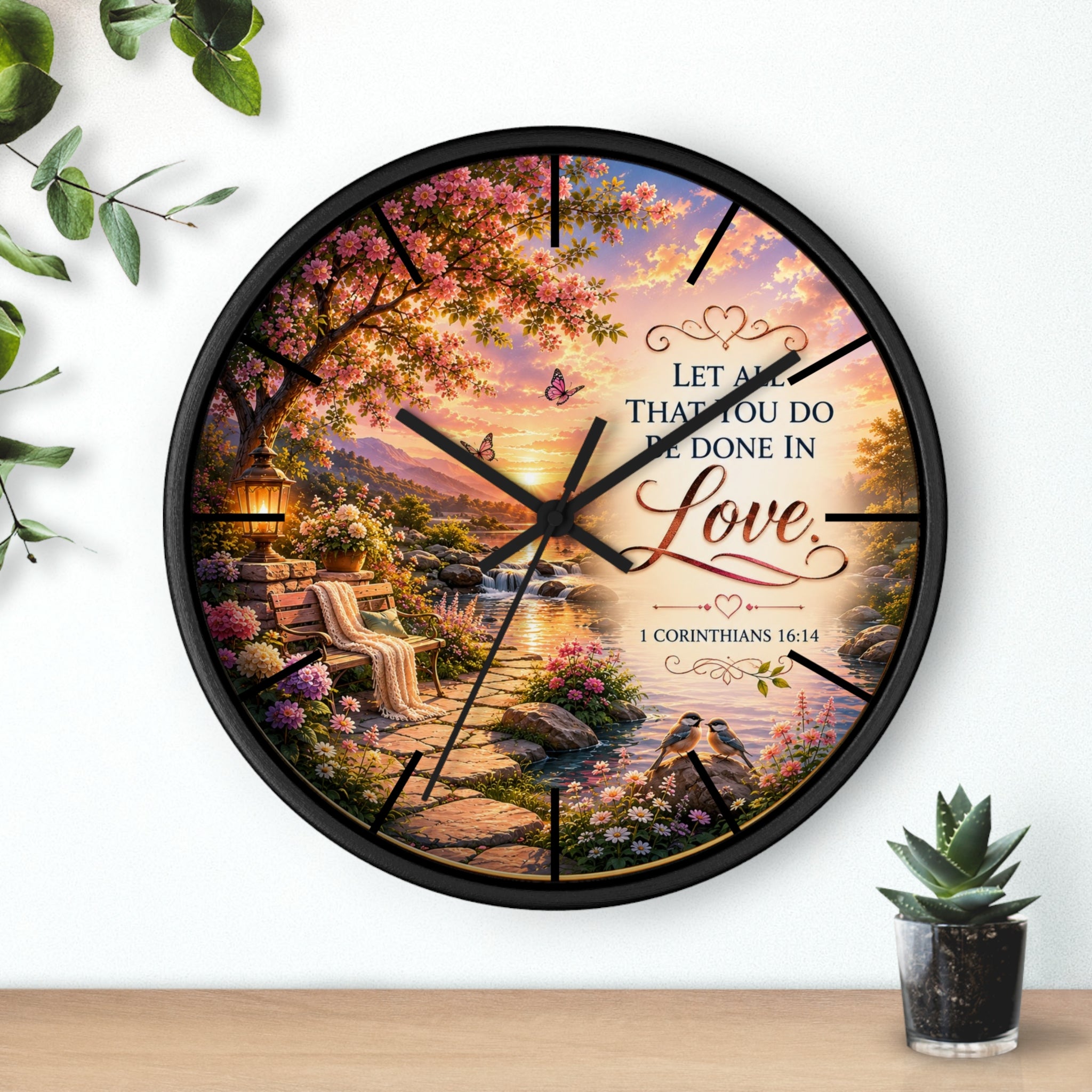 Inspirational Christian wall clock featuring a flower-lined lakeside sunrise scene with 1 Corinthians 16:14 scripture about doing all things in love.