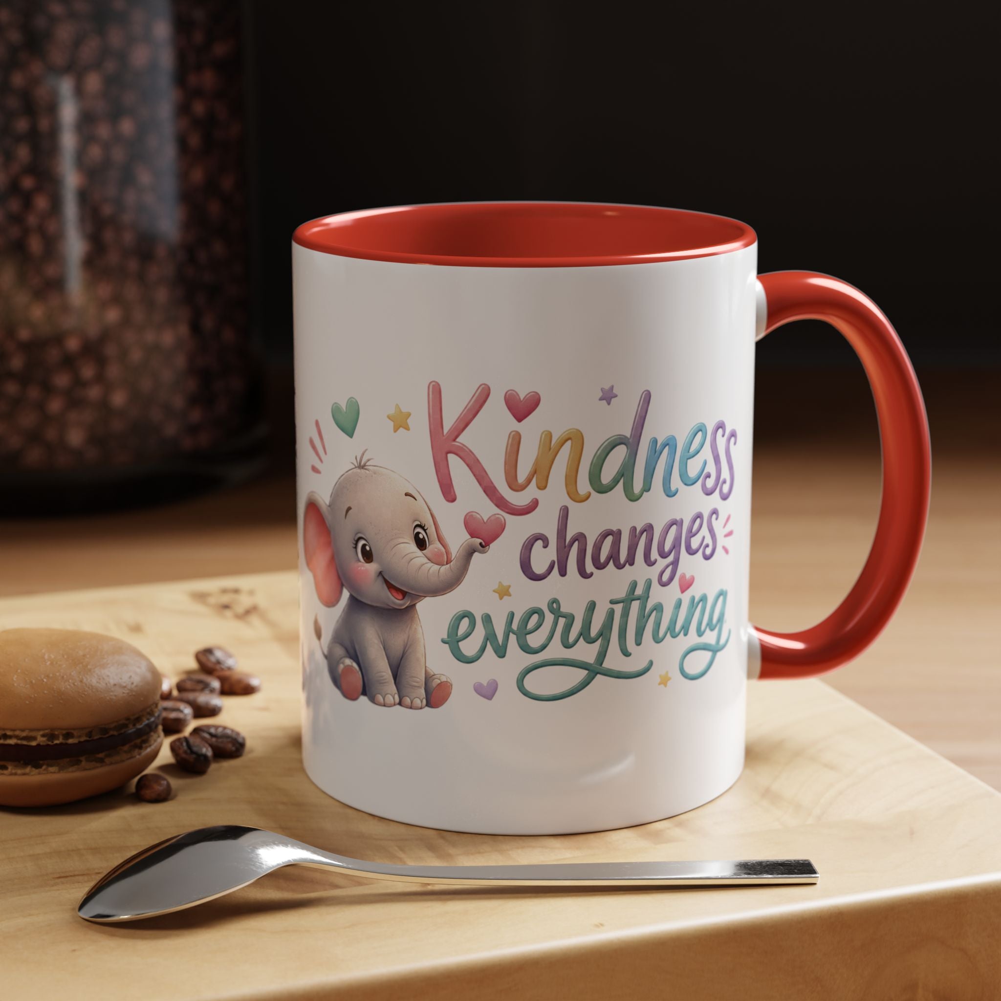 Cute ceramic coffee mug featuring a pastel baby elephant and the uplifting message “Kindness Changes Everything” with colorful accent handle and interior.