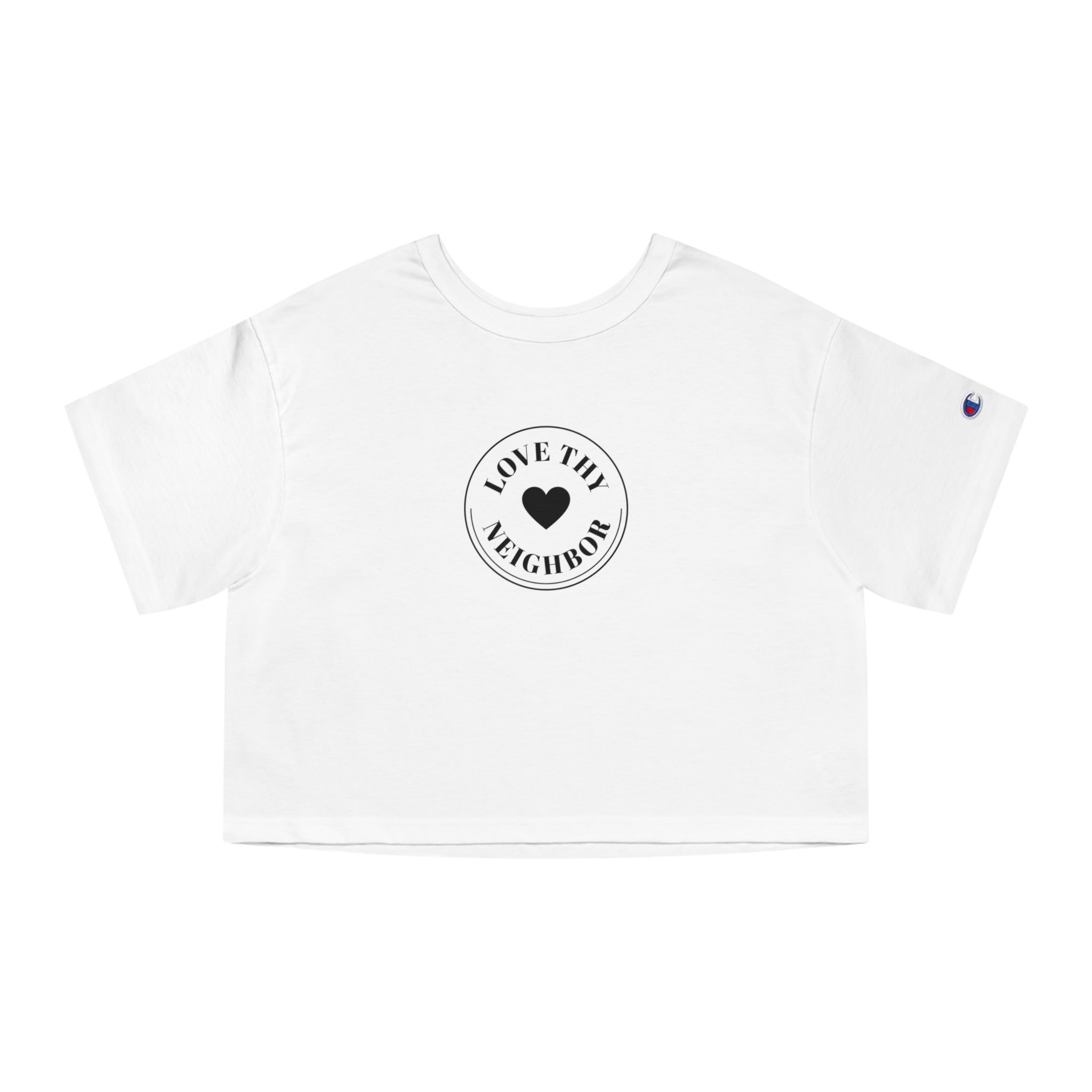 A white short-sleeve crop top t-shirt featuring a circular black graphic on the chest that reads 'LOVE THY NEIGHBOR' around a central heart. A small blue and white Champion logo is visible on the left sleeve.