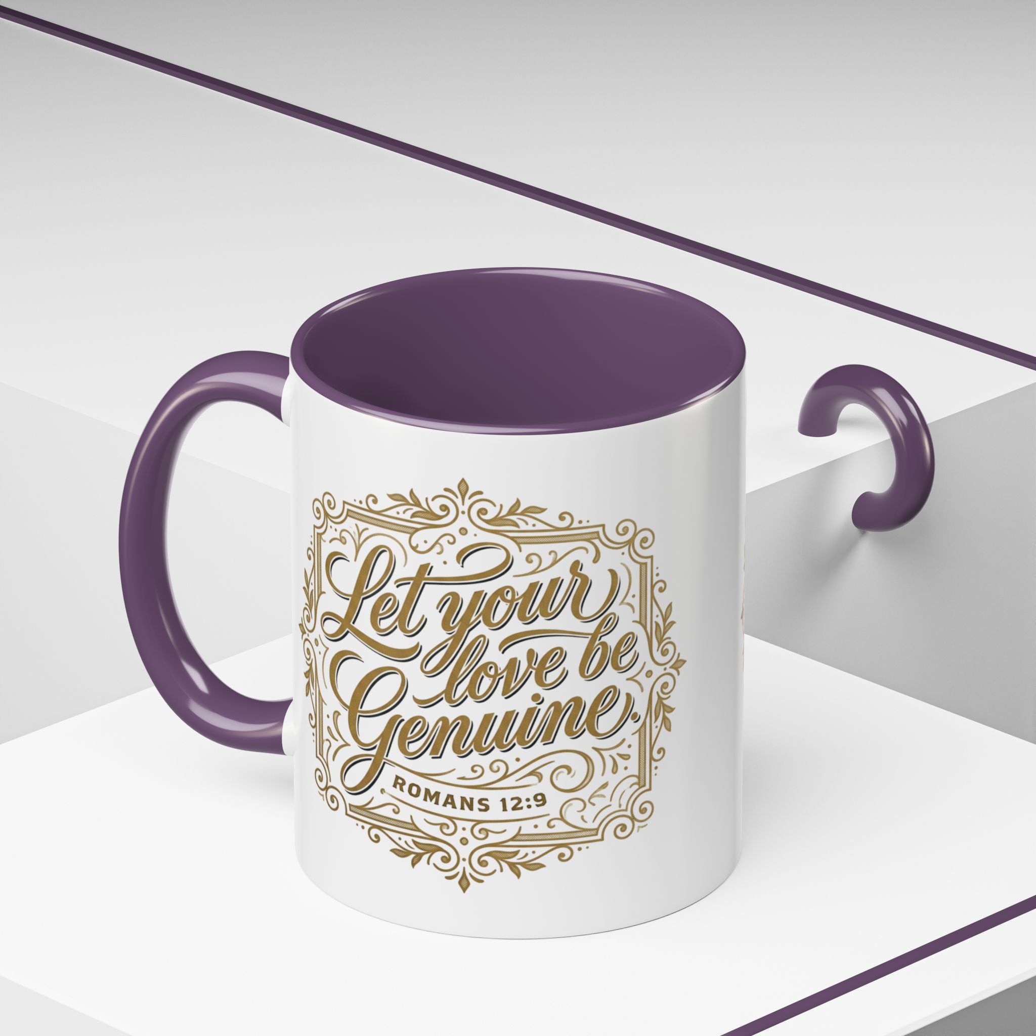 Inspirational ceramic accent coffee mug featuring Romans 12:9 and the message “Let Your Love Be Genuine” in elegant gold script with decorative flourishes and black accent handle and interior.