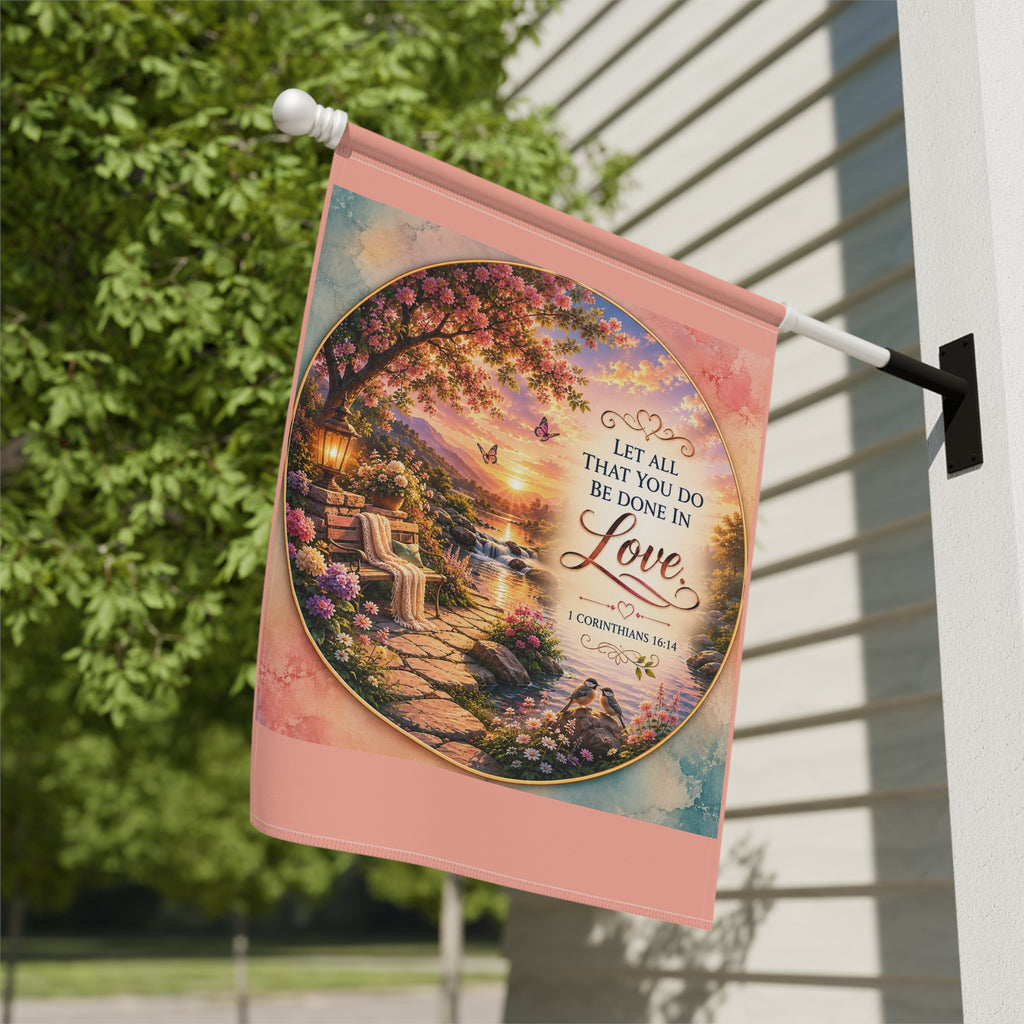 Inspirational Christian garden flag featuring a lantern-lit waterfront pathway, blooming flowers, and the scripture “Let All That You Do Be Done in Love” in warm sunset tones.