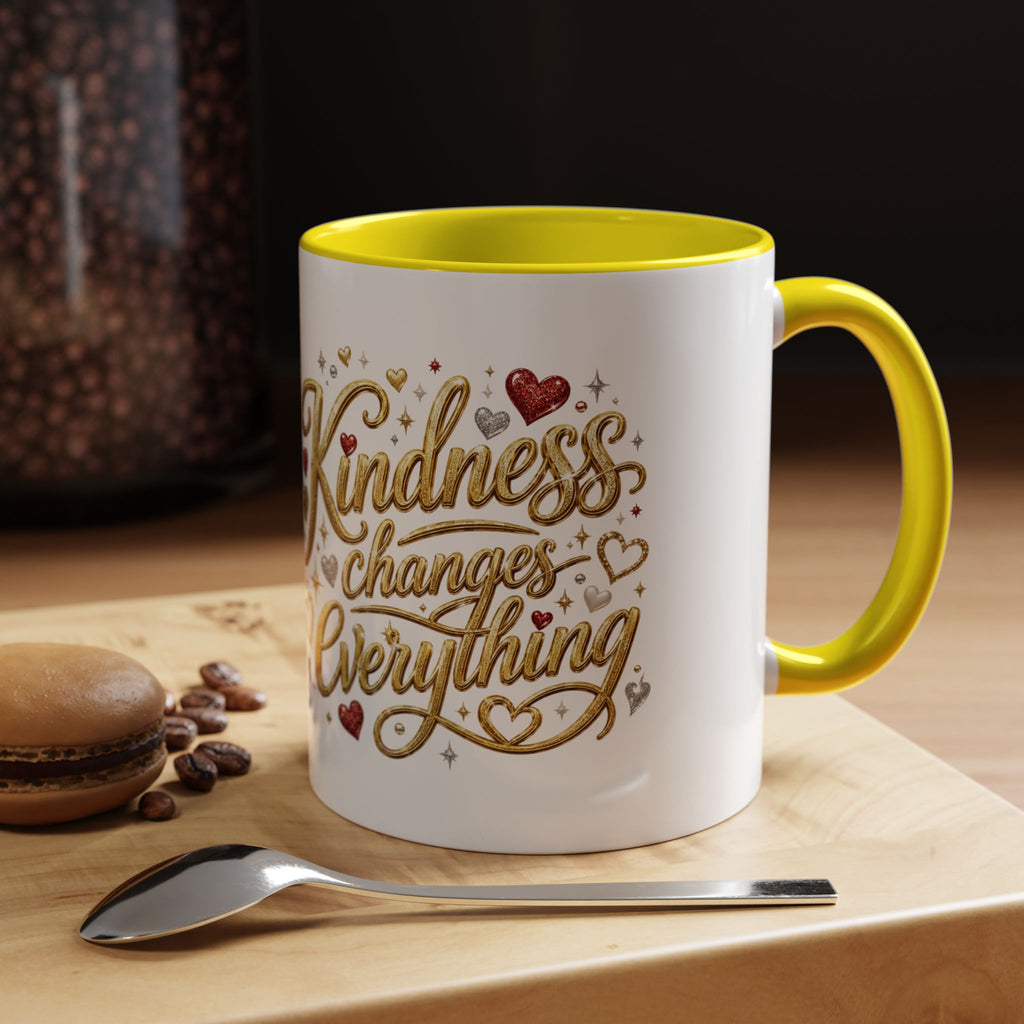 Inspirational ceramic coffee mug featuring the hand-lettered message “Kindness Changes Everything” with gold flourishes, hearts, and colorful accent handle and interior.