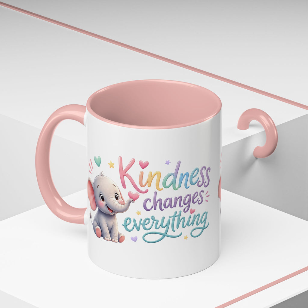 Cute ceramic coffee mug featuring a pastel baby elephant and the uplifting message “Kindness Changes Everything” with colorful accent handle and interior.