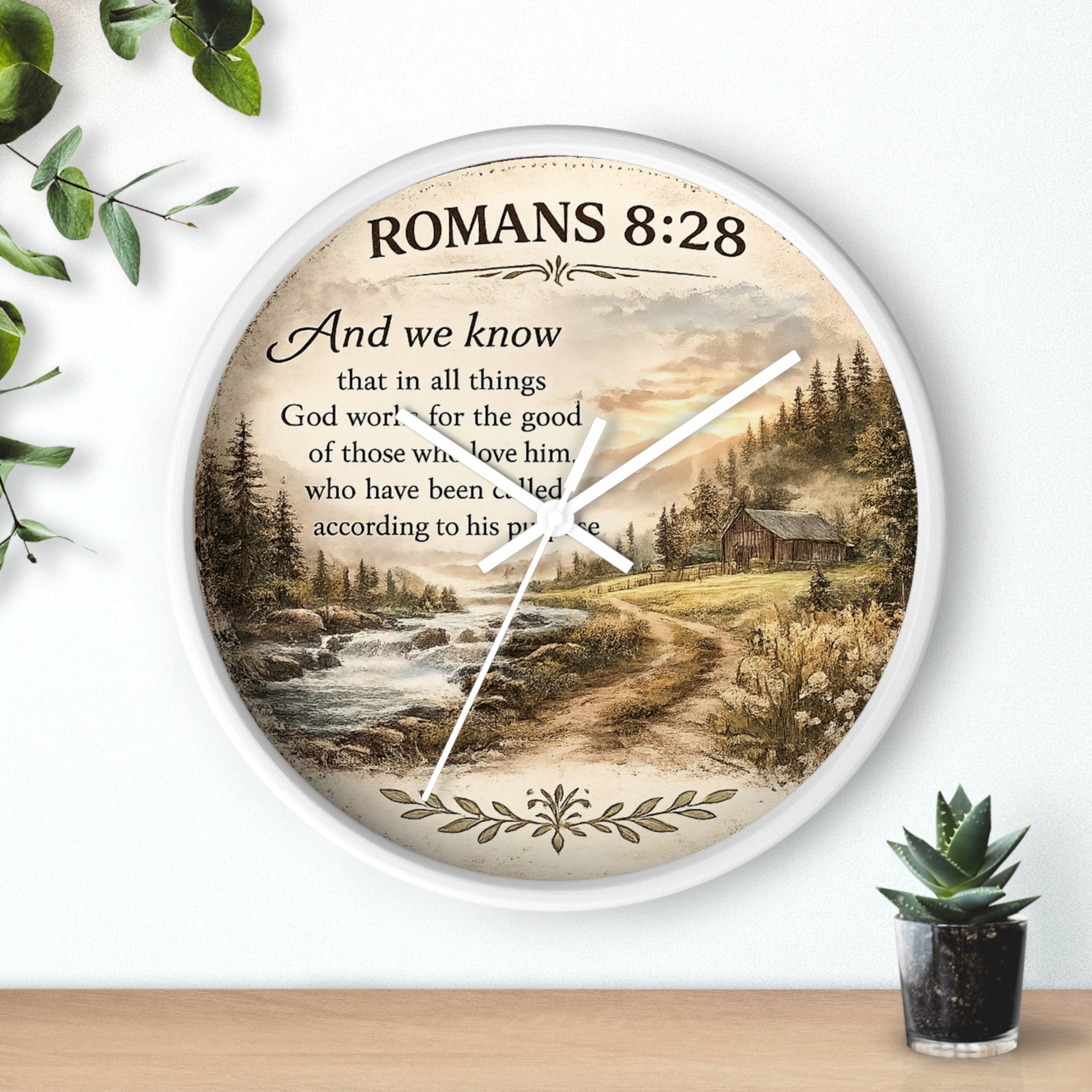 Inspirational Christian wall clock featuring Romans 8:28 scripture with a rustic cabin, flowing creek, and sunset landscape in warm countryside colors.