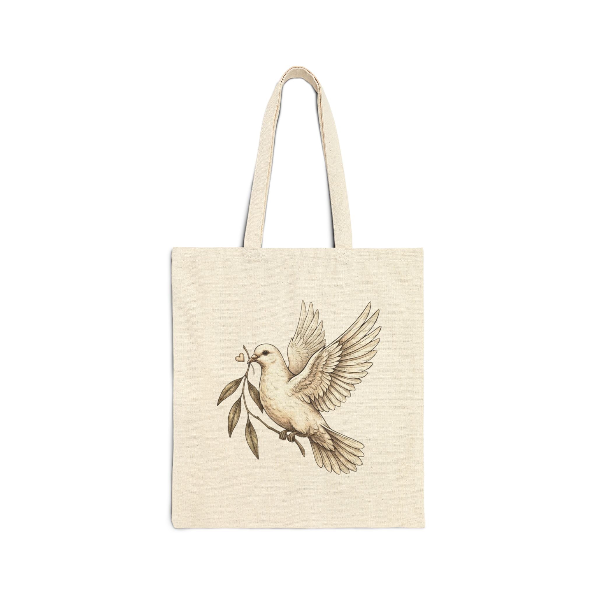 Cotton canvas tote bag featuring a vintage-style dove carrying an olive branch, symbolizing peace, hope, faith, and renewal in a rustic black-and-cream design.
