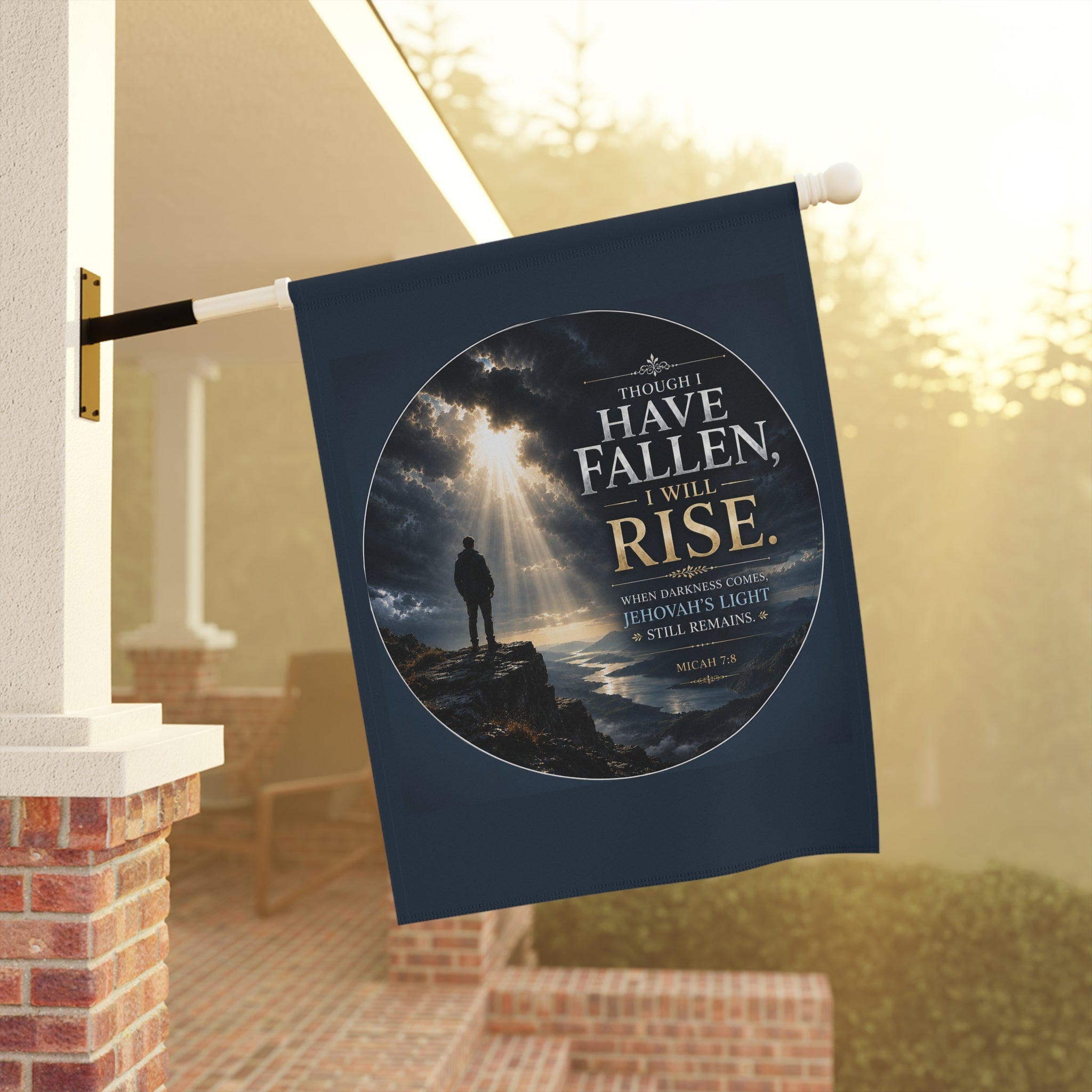 Inspirational Christian garden flag featuring golden light breaking through storm clouds over a rocky shoreline with the phrase “Though I Have Fallen, I Will Rise.”