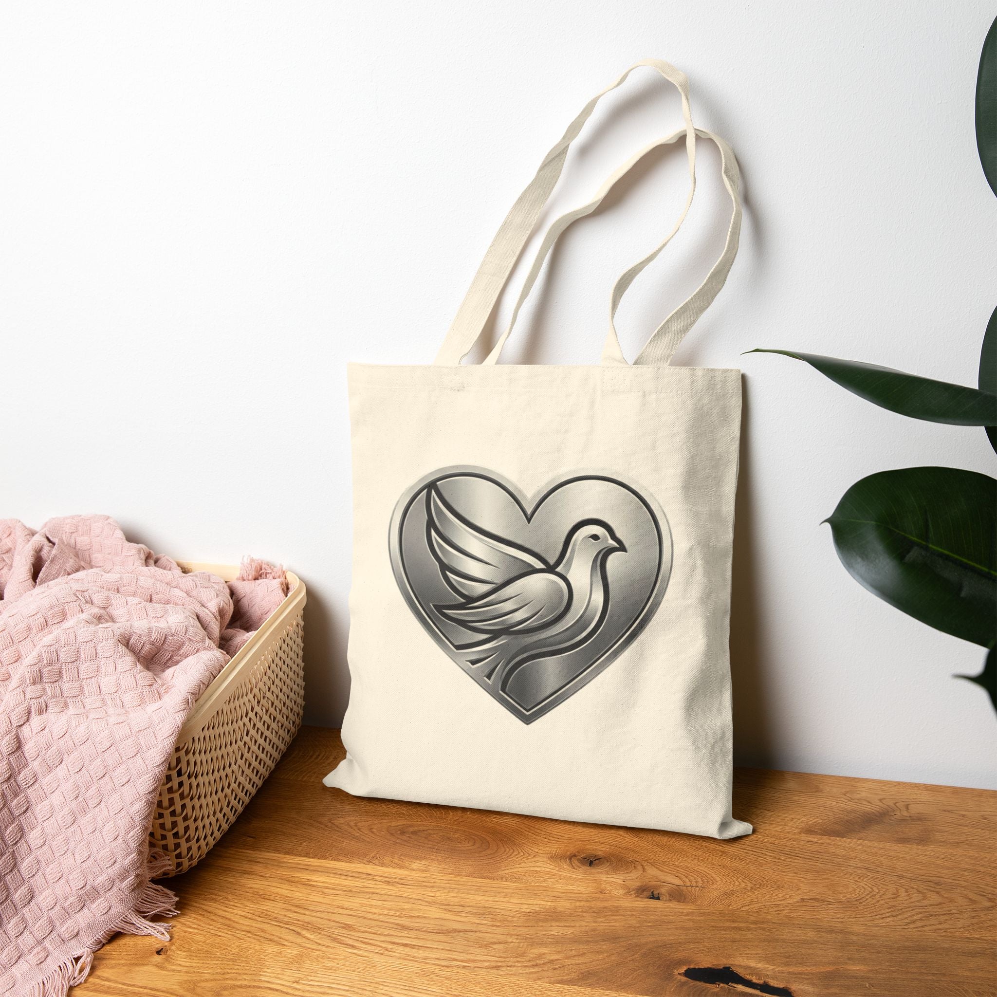 Cotton canvas tote bag featuring a silver dove inside a heart design, symbolizing peace, love, faith, hope, and encouragement in an elegant minimalist style.