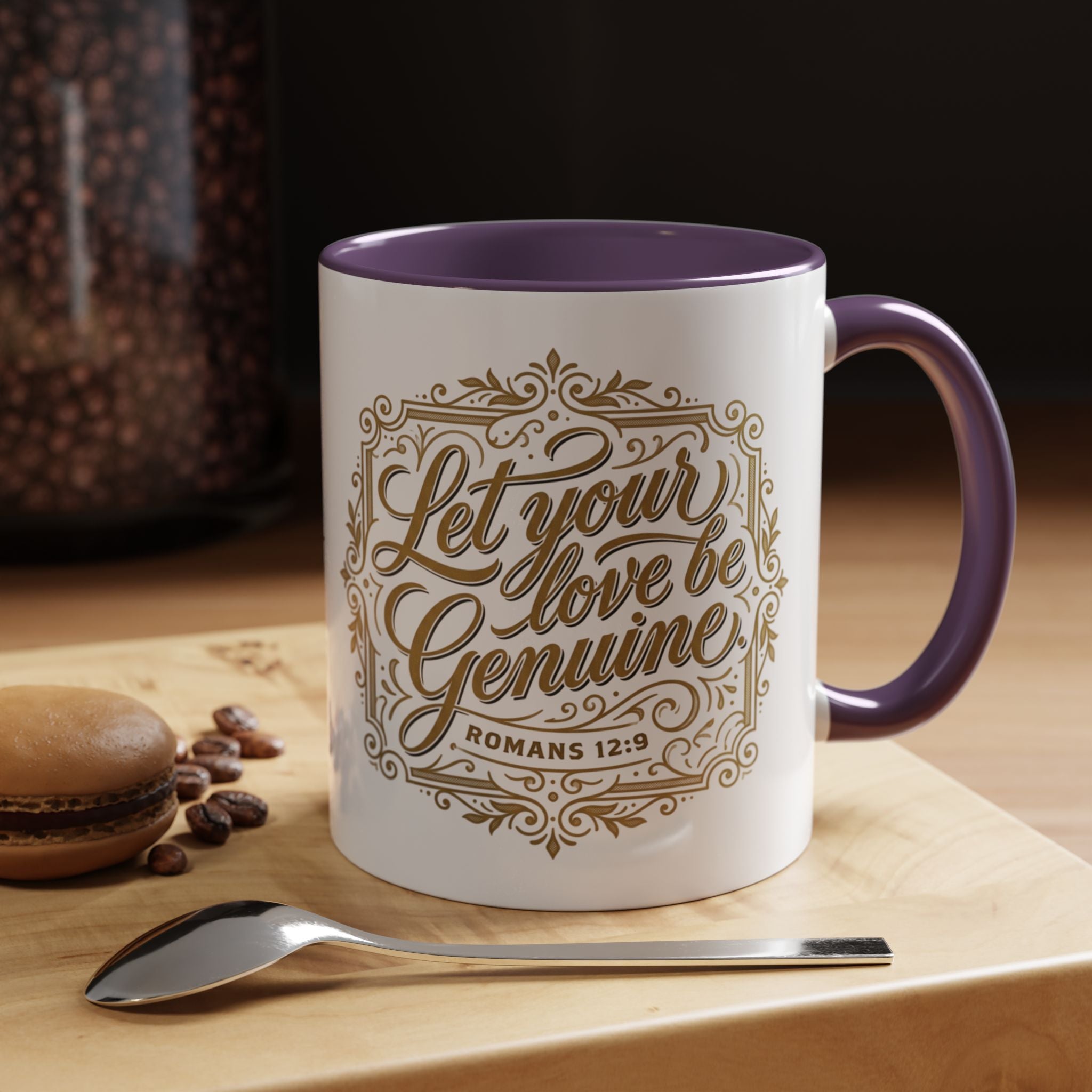 Inspirational ceramic accent coffee mug featuring Romans 12:9 and the message “Let Your Love Be Genuine” in elegant gold script with decorative flourishes and black accent handle and interior.