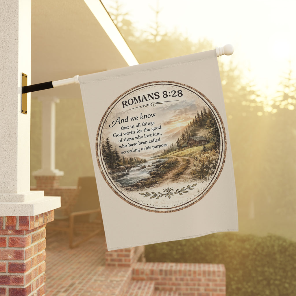 Christian garden flag featuring Romans 8:28 above a rustic river landscape with pine-covered hills, sunrise scenery, and farmhouse-inspired outdoor décor styling.