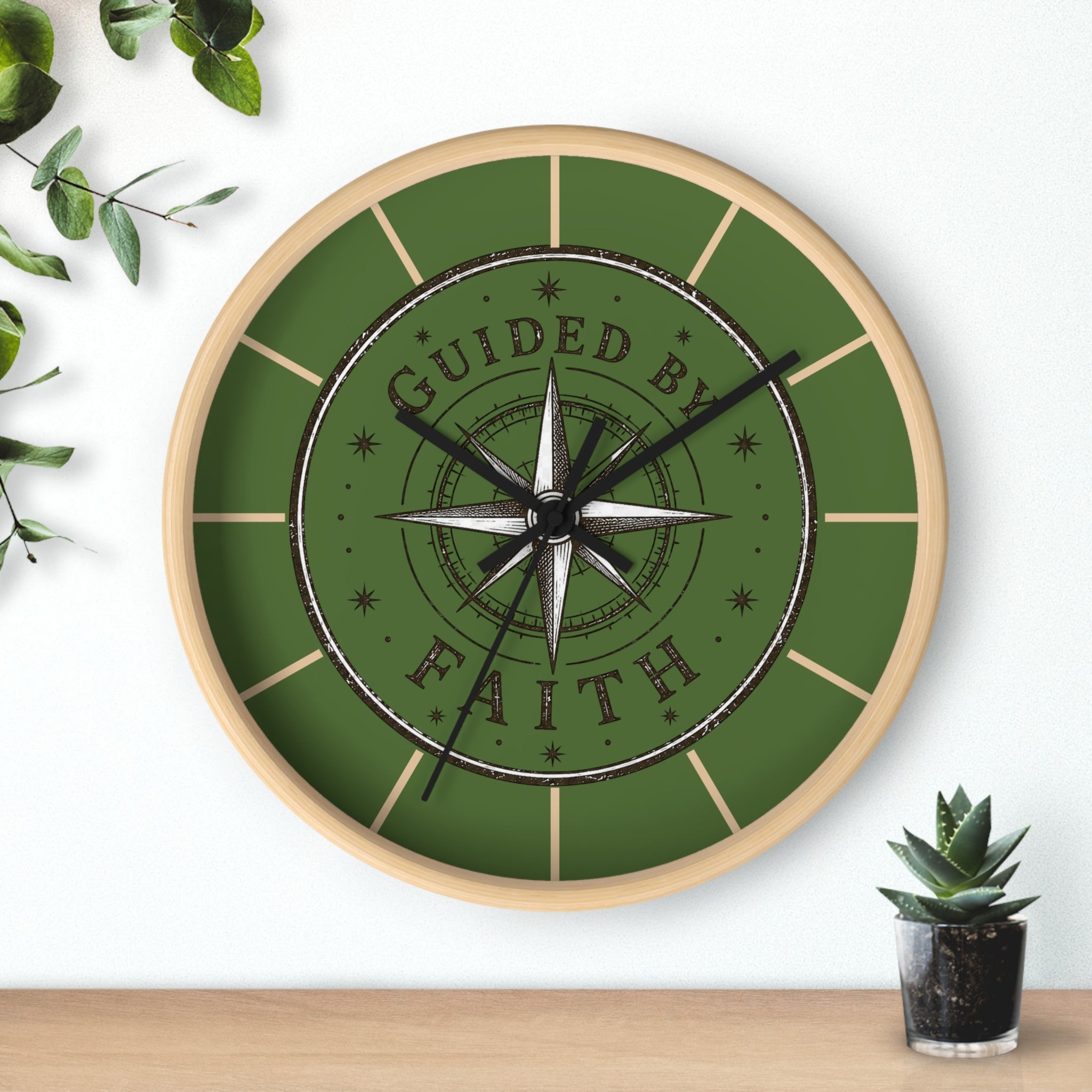 Rustic inspirational wall clock featuring a vintage compass design and the words “Guided by Faith” on an olive-green distressed background with silent movement.