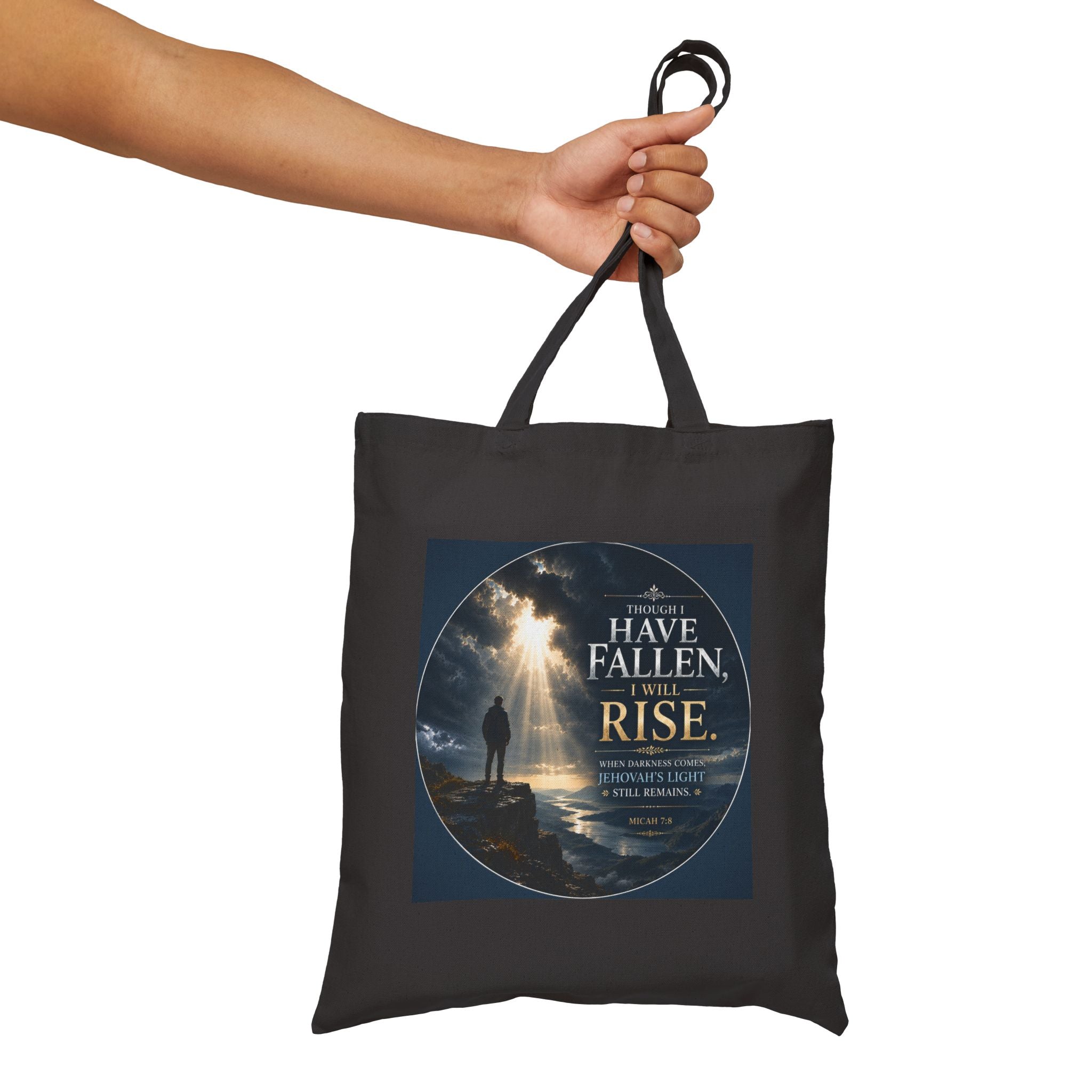 Christian cotton canvas tote bag featuring Micah 7:8 and the message “Though I Have Fallen, I Will Rise,” with dramatic mountain landscape artwork, storm clouds, rays of light, and inspirational faith-based design.