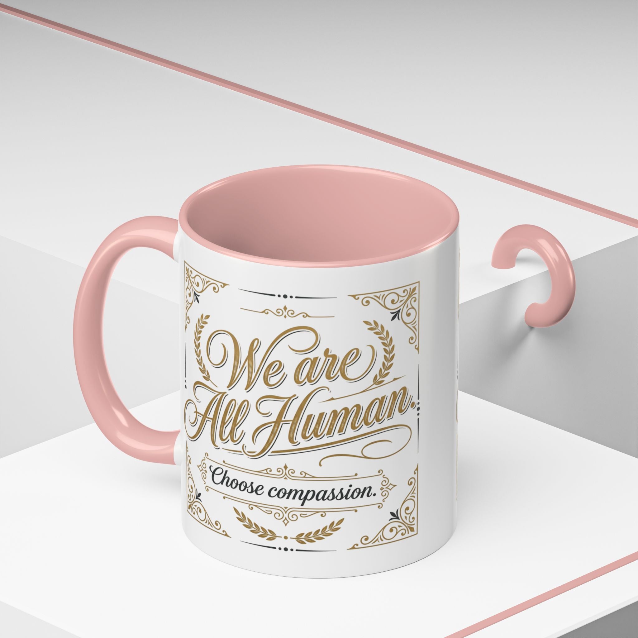 Inspirational ceramic accent coffee mug featuring “We Are All Human – Choose Compassion” in vintage-style gold lettering with decorative flourishes and black accent handle and interior.