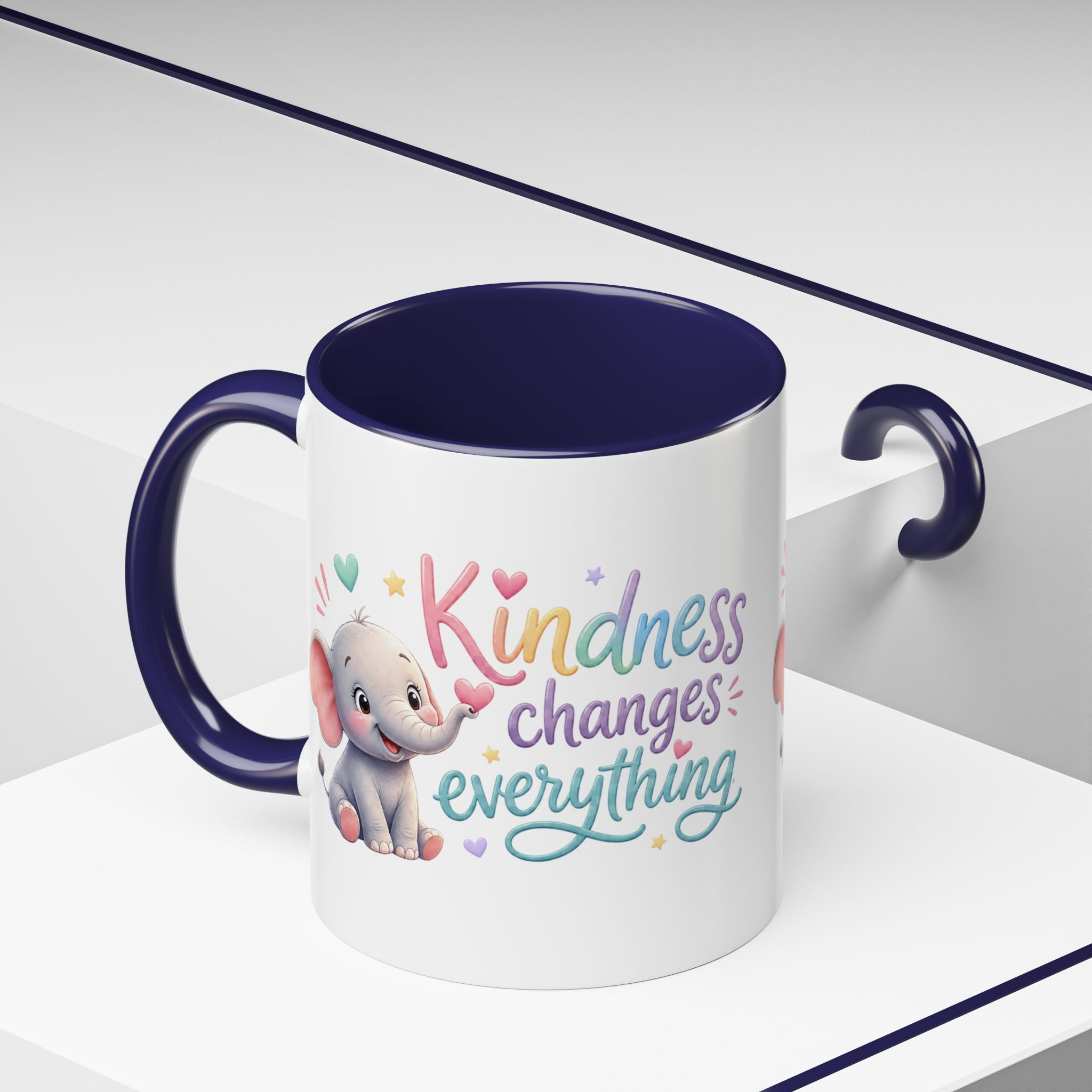 Cute ceramic coffee mug featuring a pastel baby elephant and the uplifting message “Kindness Changes Everything” with colorful accent handle and interior.