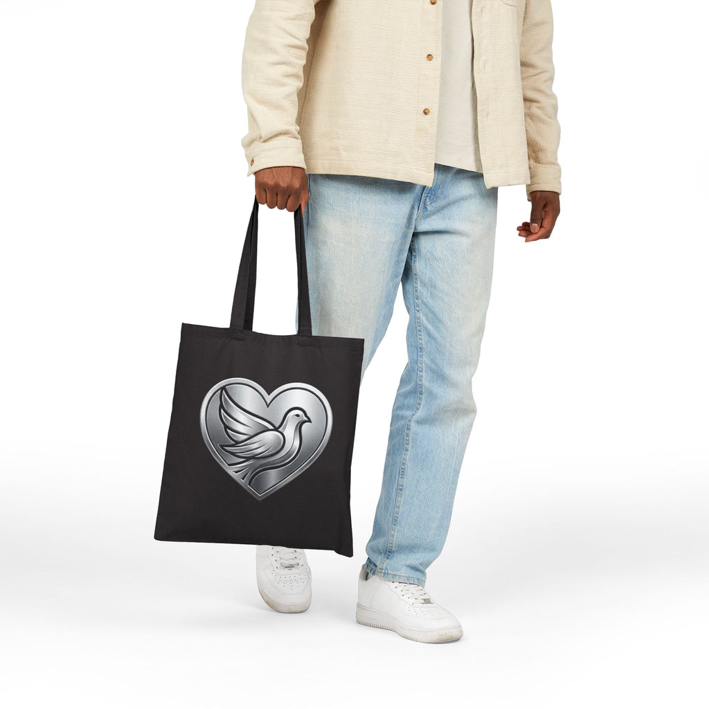 Cotton canvas tote bag featuring a silver dove inside a heart design, symbolizing peace, love, faith, hope, and encouragement in an elegant minimalist style.
