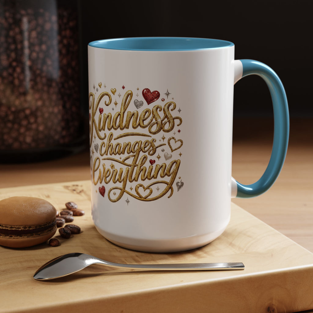 Inspirational ceramic coffee mug featuring the hand-lettered message “Kindness Changes Everything” with gold flourishes, hearts, and colorful accent handle and interior.