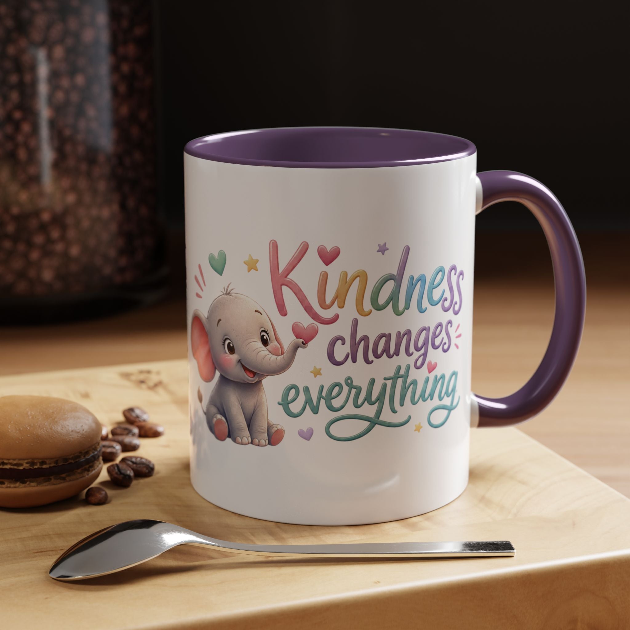 Cute ceramic coffee mug featuring a pastel baby elephant and the uplifting message “Kindness Changes Everything” with colorful accent handle and interior.