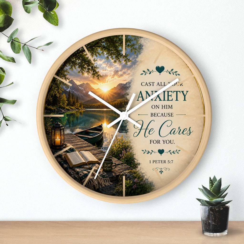 Inspirational Christian wall clock featuring a peaceful lakeside sunrise with a dock, canoe, and 1 Peter 5:7 scripture about casting anxiety on Him.